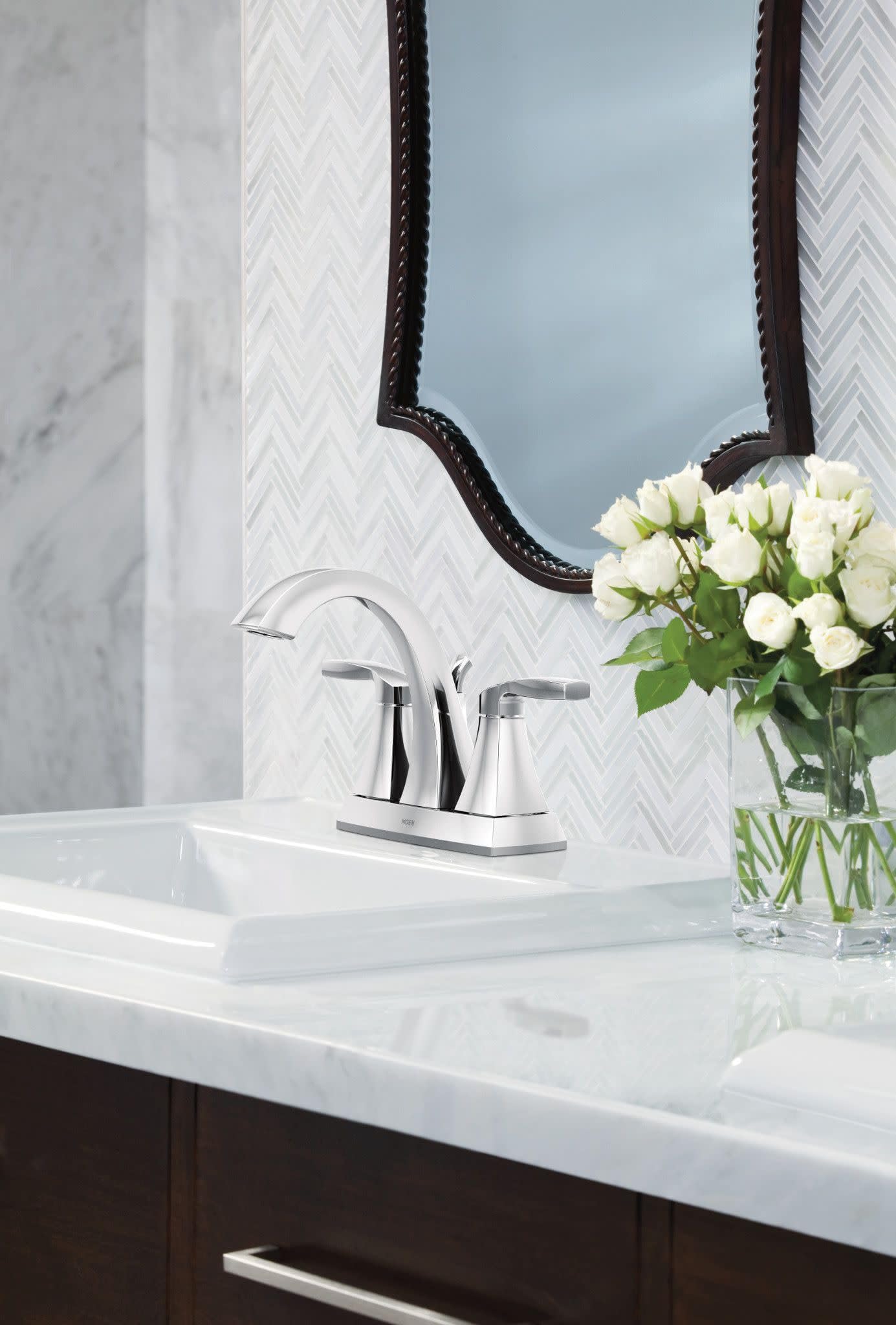 Chrome two-handle high arc bathroom faucet with curved spout mounted on white sink counter.