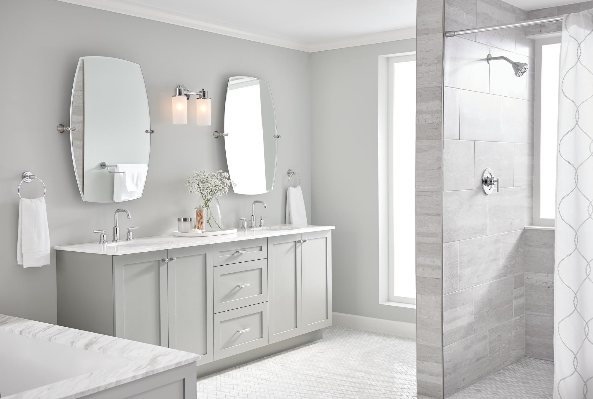 Chrome single-handle shower trim kit mounted on tiled shower wall with showerhead and controls visible.