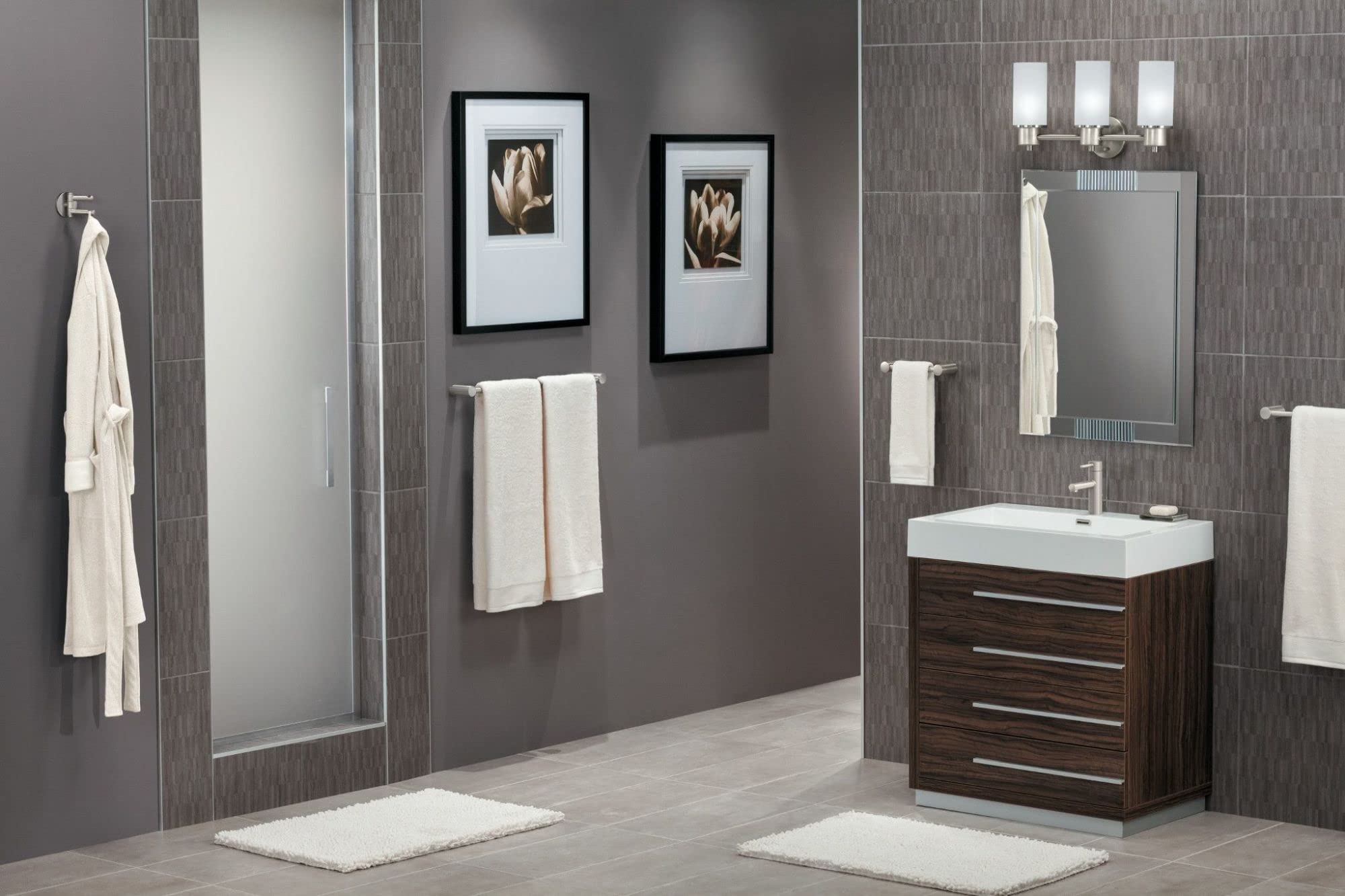 Brushed nickel 24-inch wall-mounted towel bar holding folded white towels in a bathroom setting.