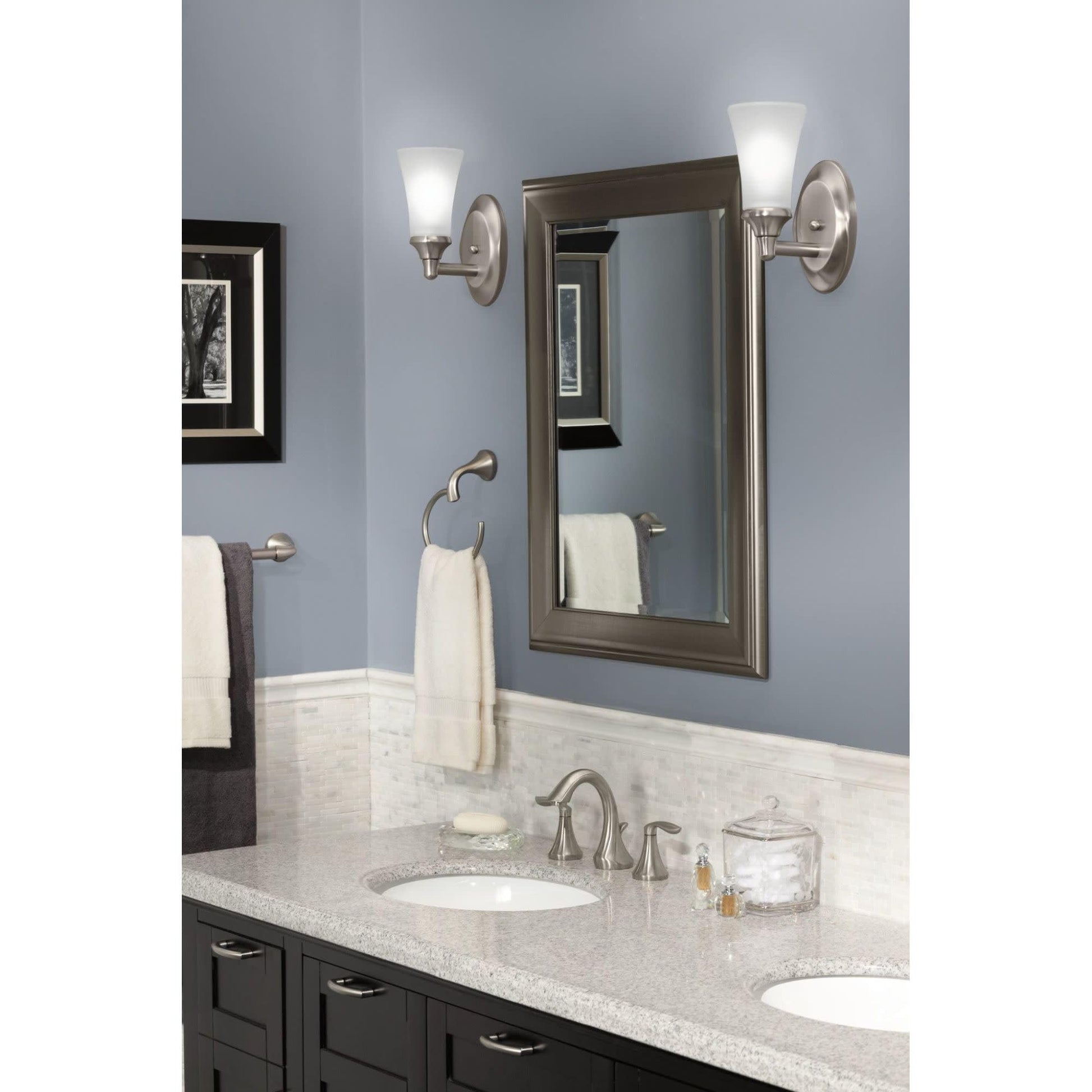 Oil-rubbed bronze vanity light fixture with two frosted glass shades mounted on either side of bathroom mirror.