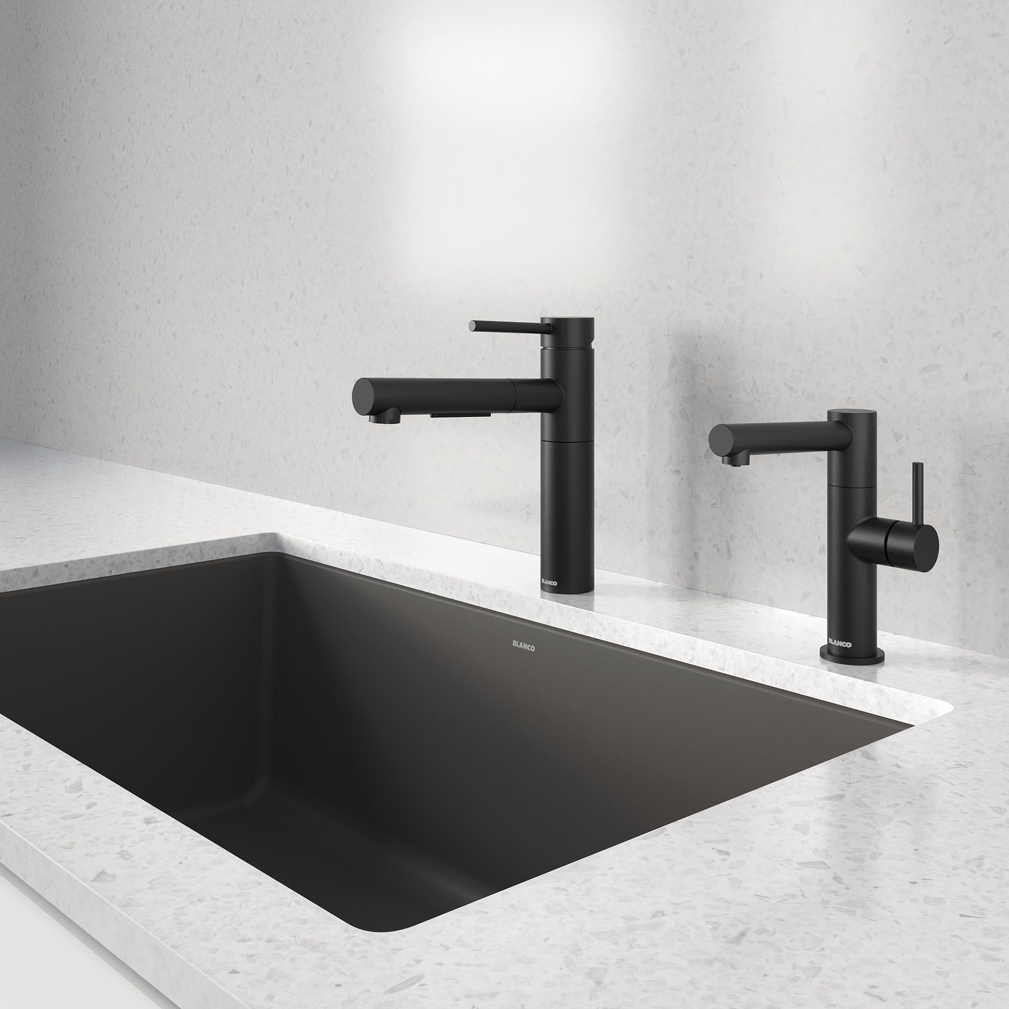 Matte black pull-out kitchen faucet with tall spout and single lever handle mounted above black undermount sink.