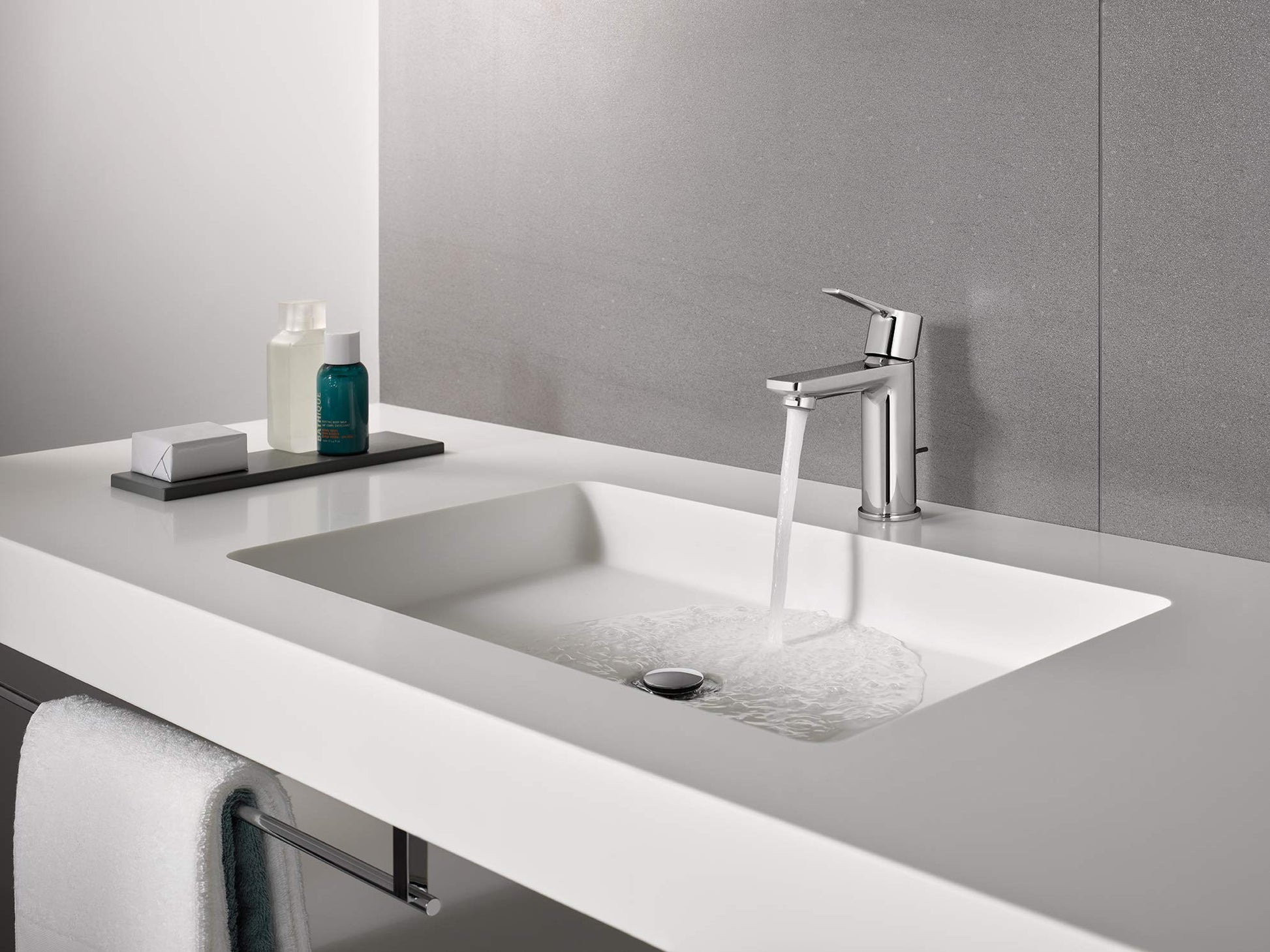 Chrome single-handle bathroom faucet with angular spout mounted above white rectangular sink basin.