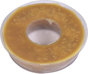 Round tan wax ring with center hole in clear plastic container.