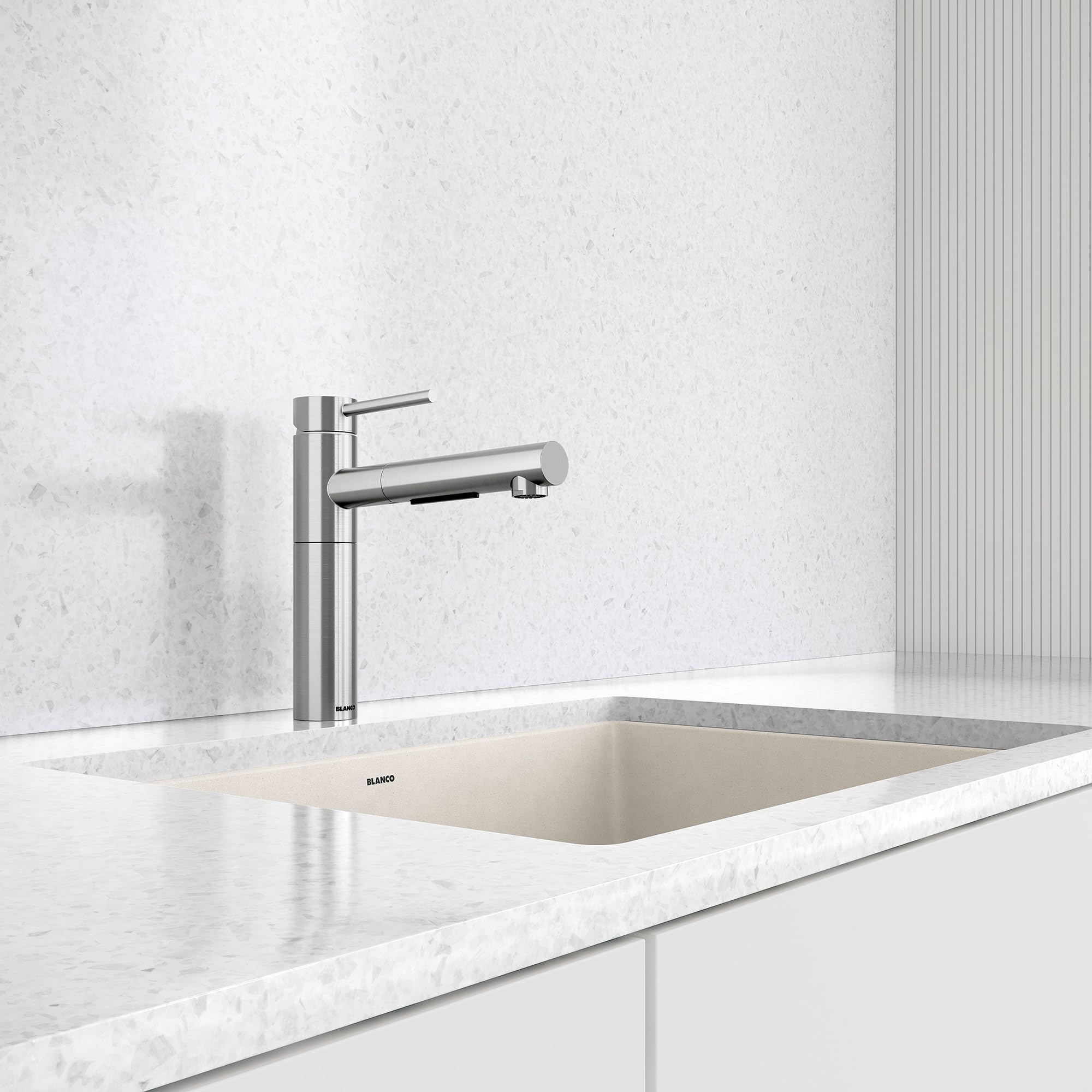 Stainless steel pull-out kitchen faucet with single lever handle mounted above white undermount sink.