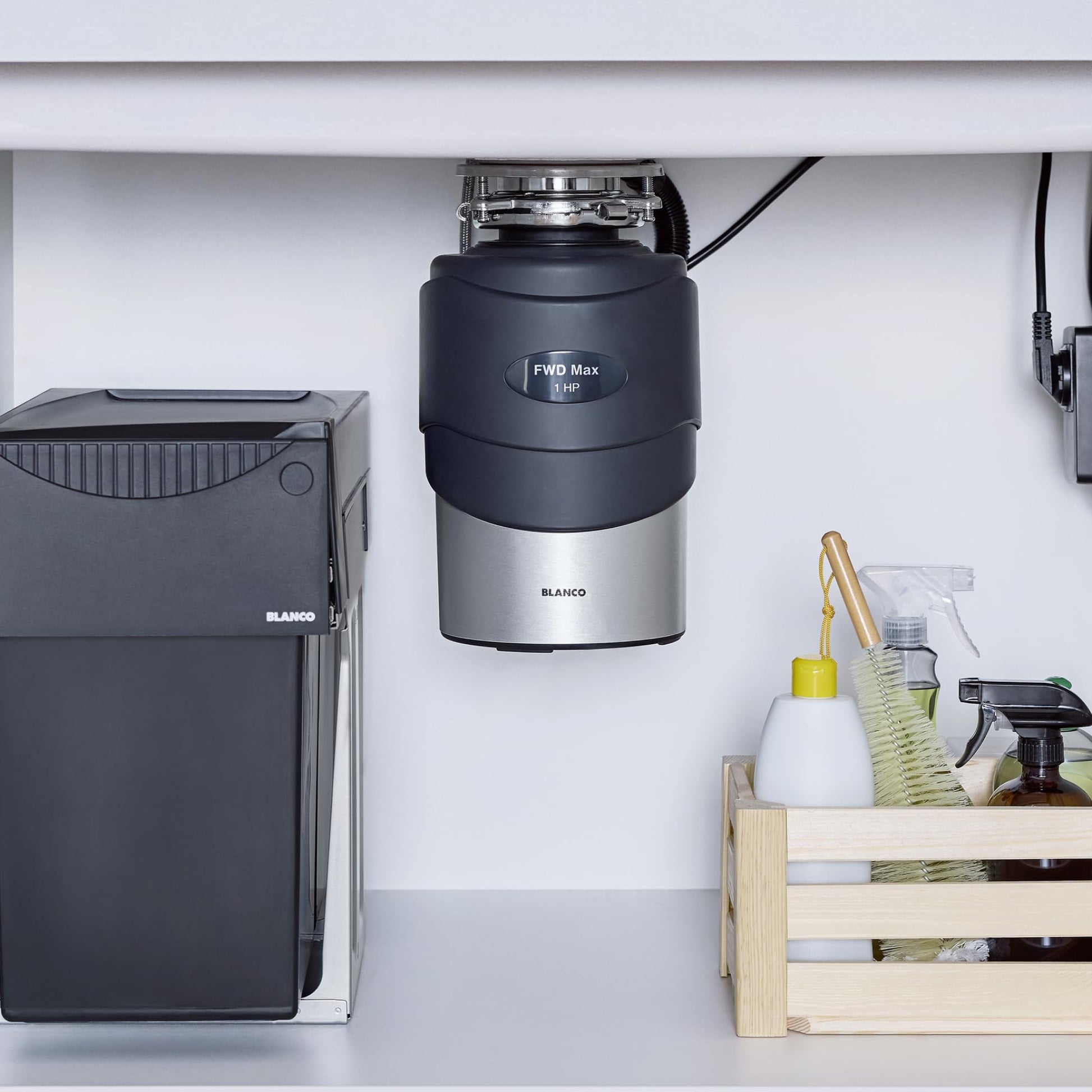 Black and stainless steel Blanco food waste disposal unit mounted under kitchen sink with FWD Max label visible.