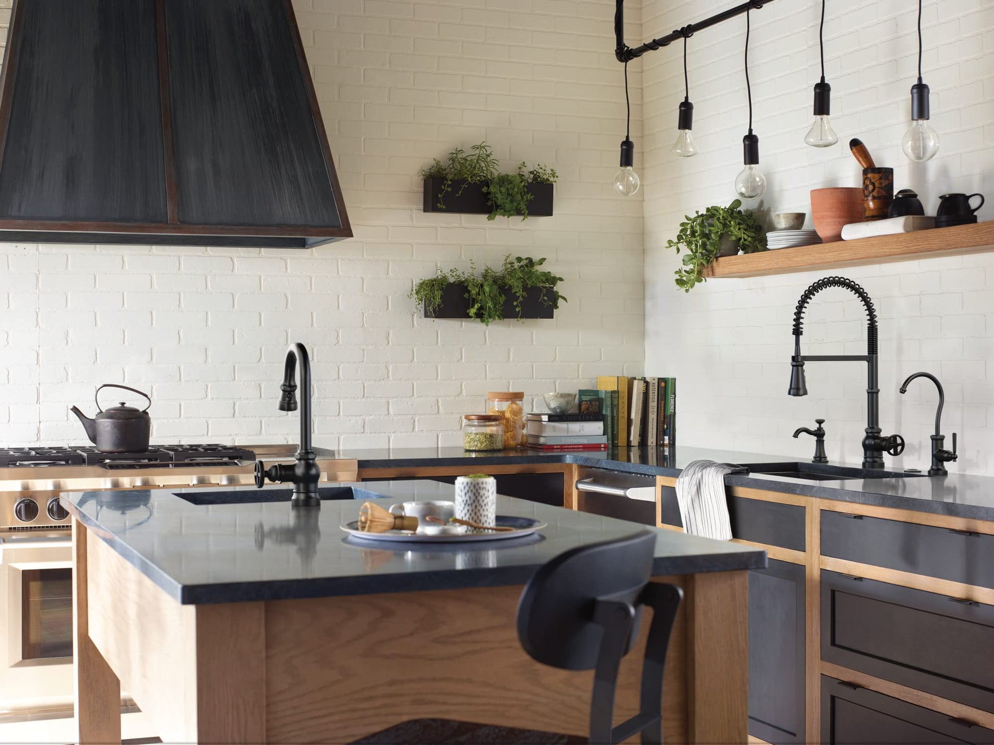 Matte black deck-mounted kitchen soap dispenser with refillable bottle installed on sink counter next to faucet.