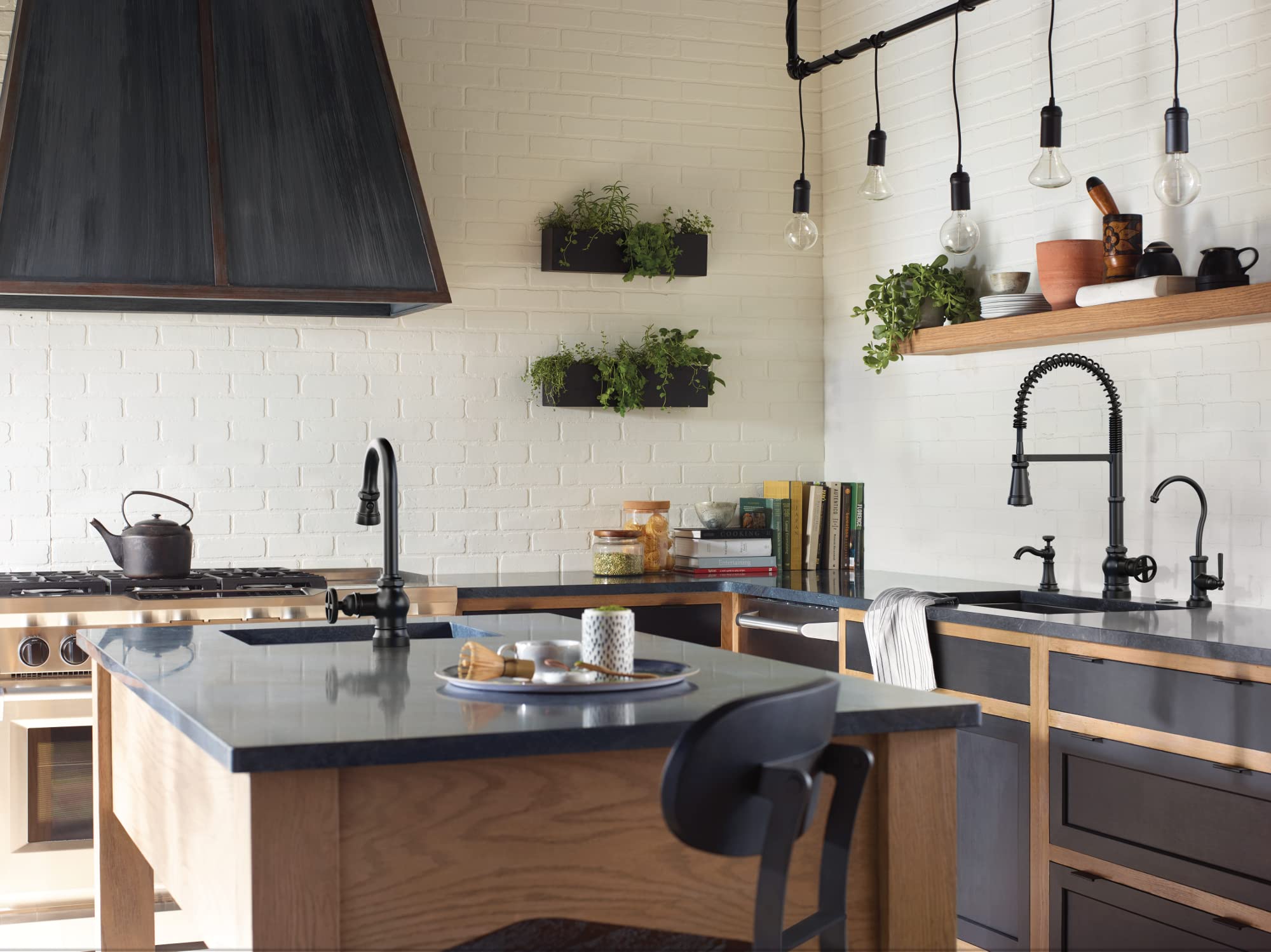 Matte black deck-mounted kitchen soap dispenser with refillable bottle installed on sink counter next to faucet.