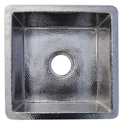 Polished nickel square sink with hammered texture interior and drain opening, viewed from above.