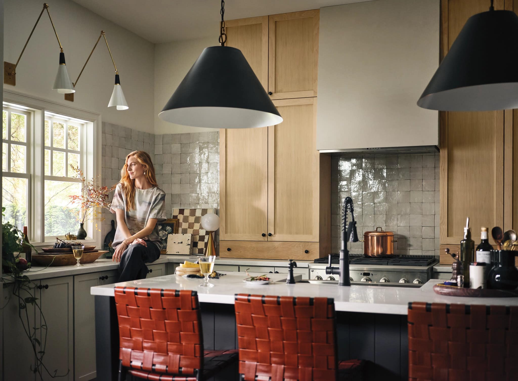 Matte black single-handle kitchen faucet with pull-down spray head mounted on white countertop in modern kitchen.