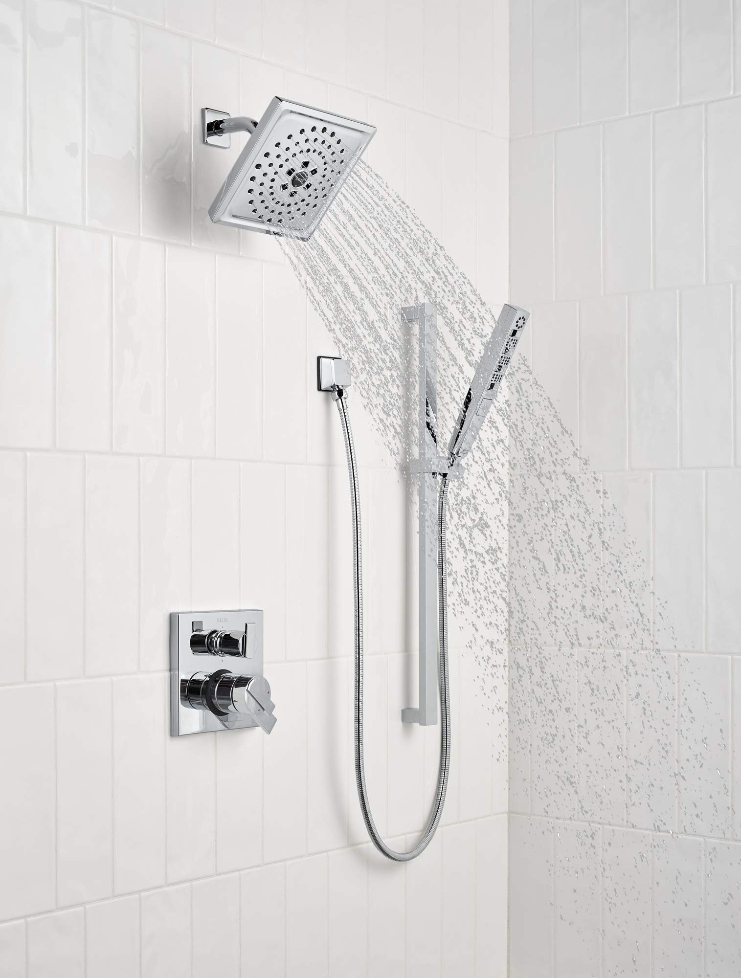Black stainless steel shower head with perforated face mounted on wall with handheld spray wand and control valve below.