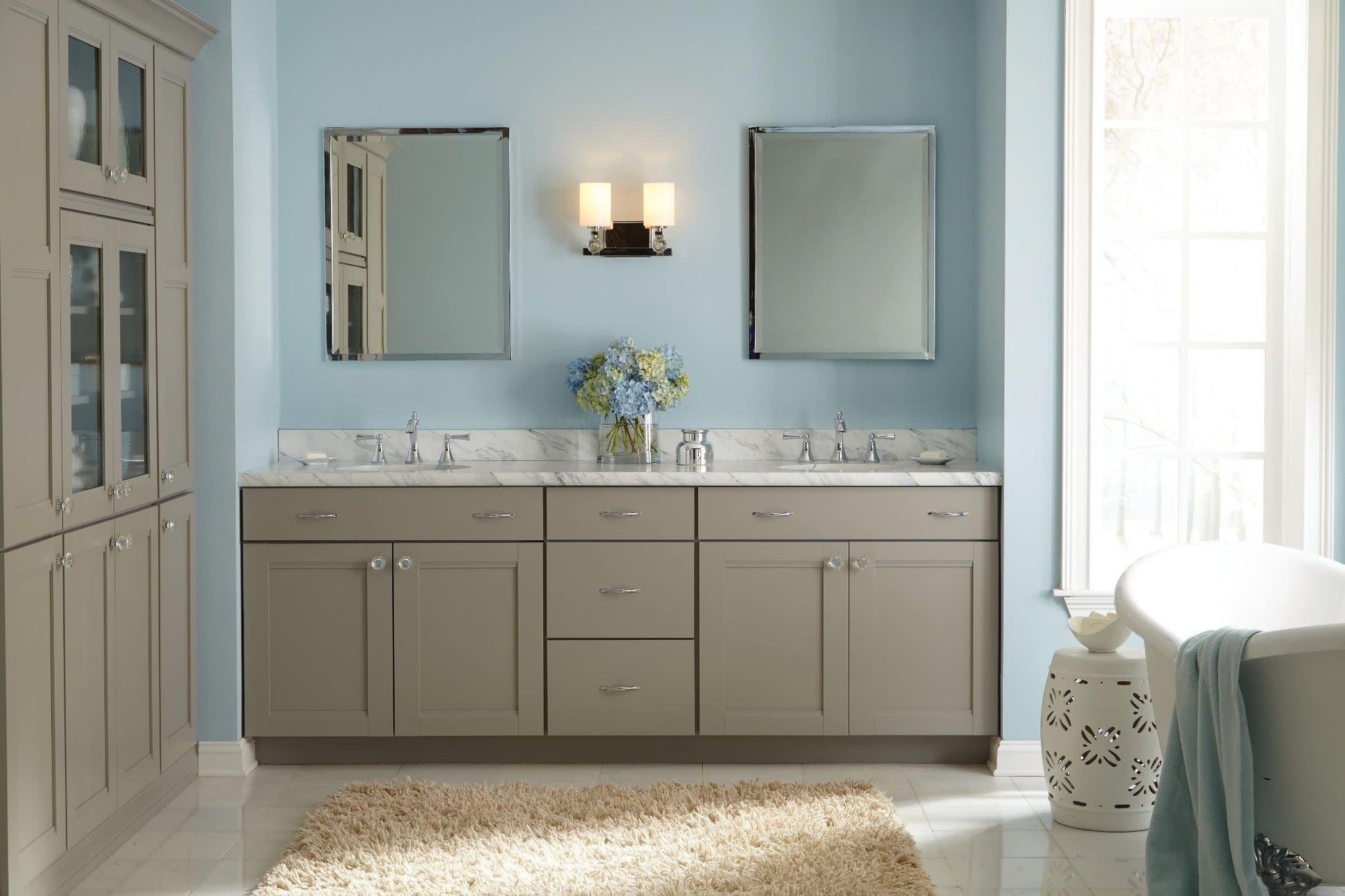 Chrome two-handle widespread bathroom faucet with high arc spout and lever handles mounted on marble vanity.