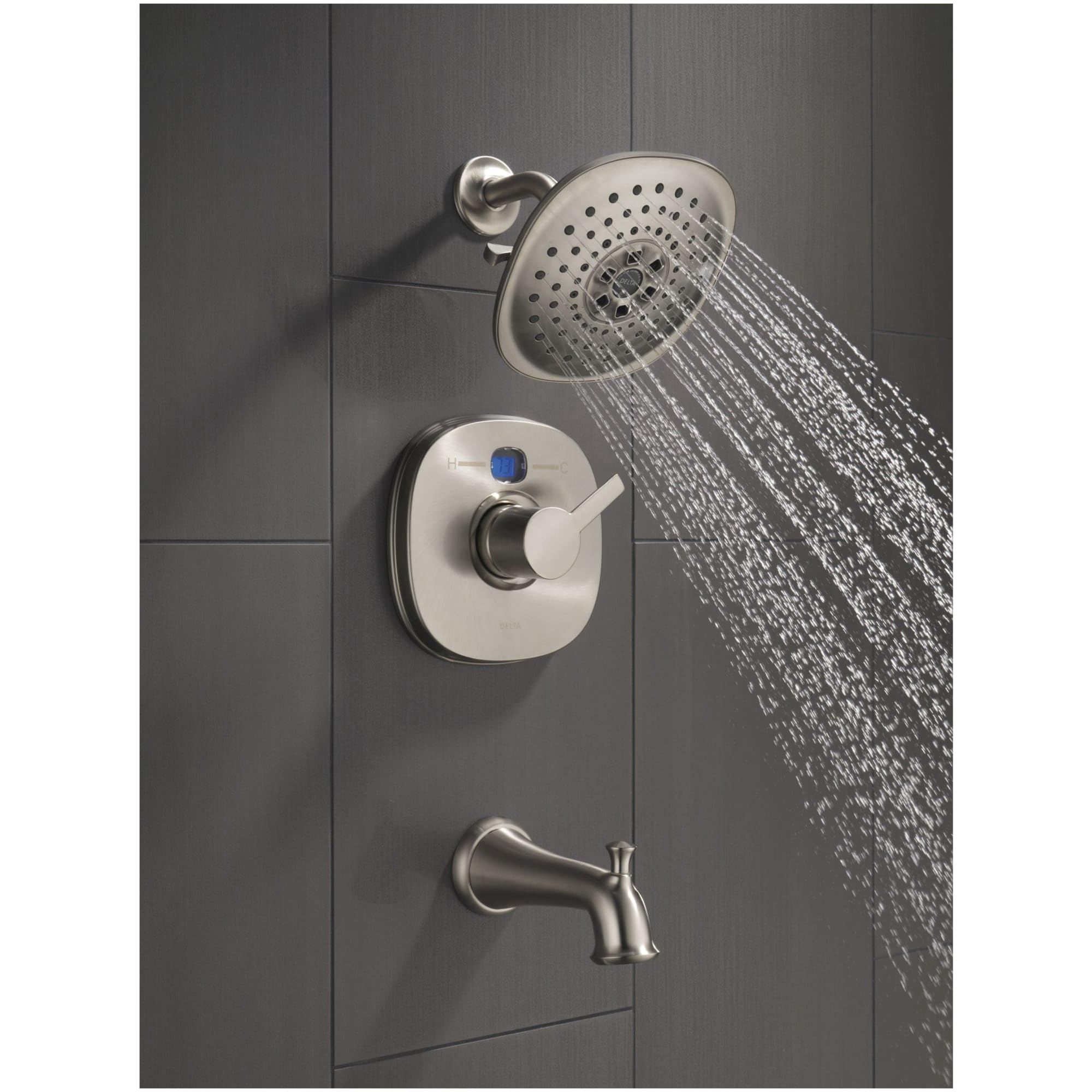 Polished nickel shower system with round showerhead, control valve with blue indicator, and tub spout mounted on tile wall.