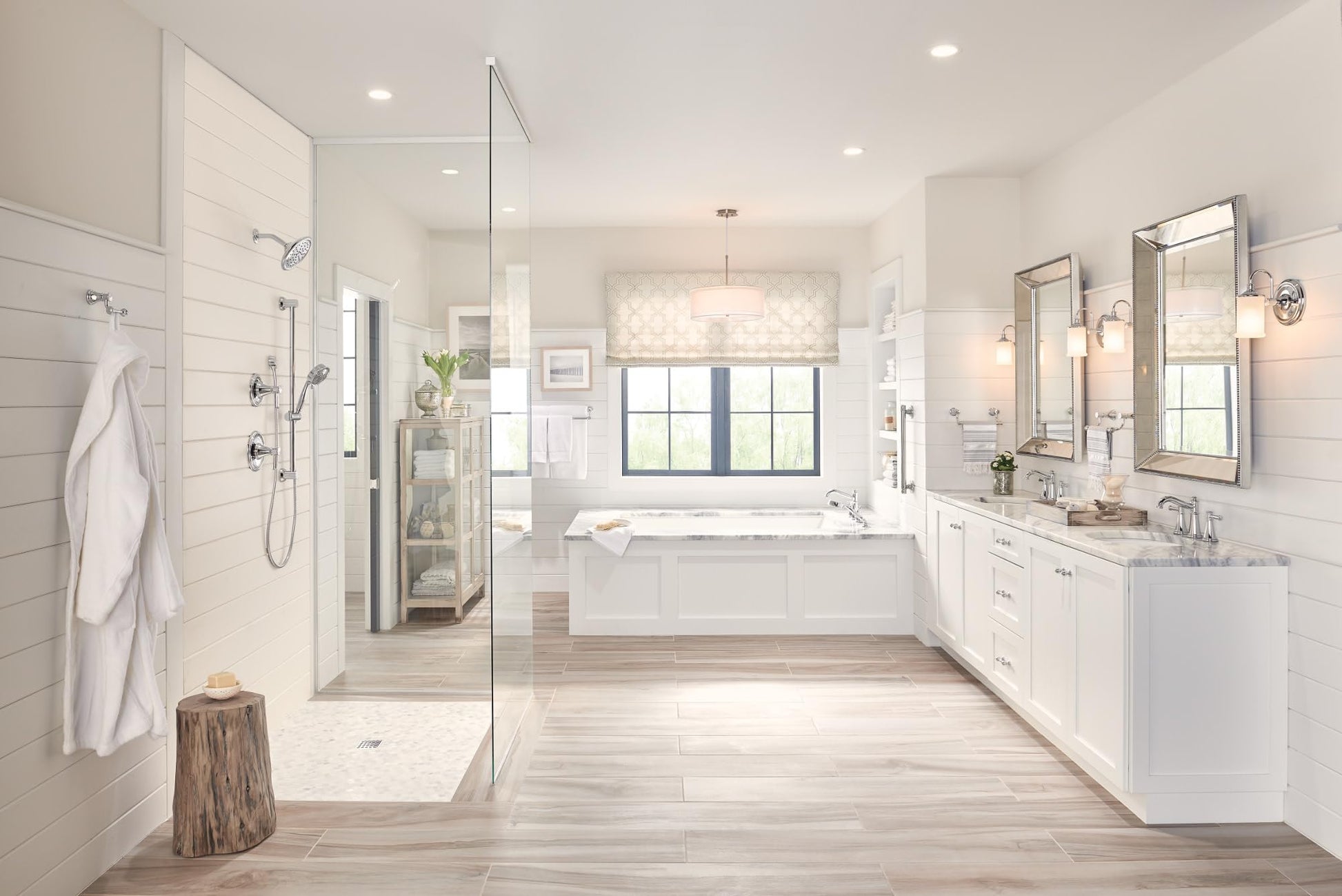 Polished nickel Roman tub faucet trim with handshower mounted on bathtub in bathroom setting.