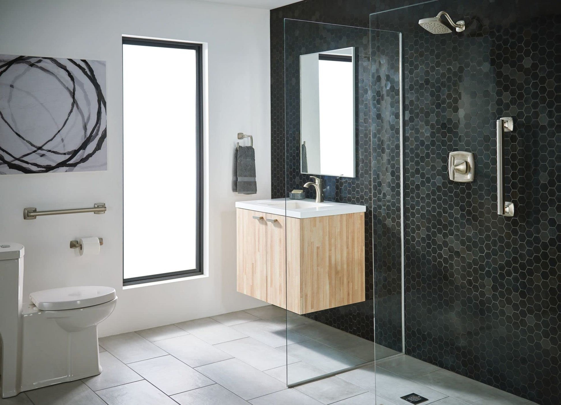 Brushed nickel pivoting toilet paper holder mounted on bathroom wall beside toilet.