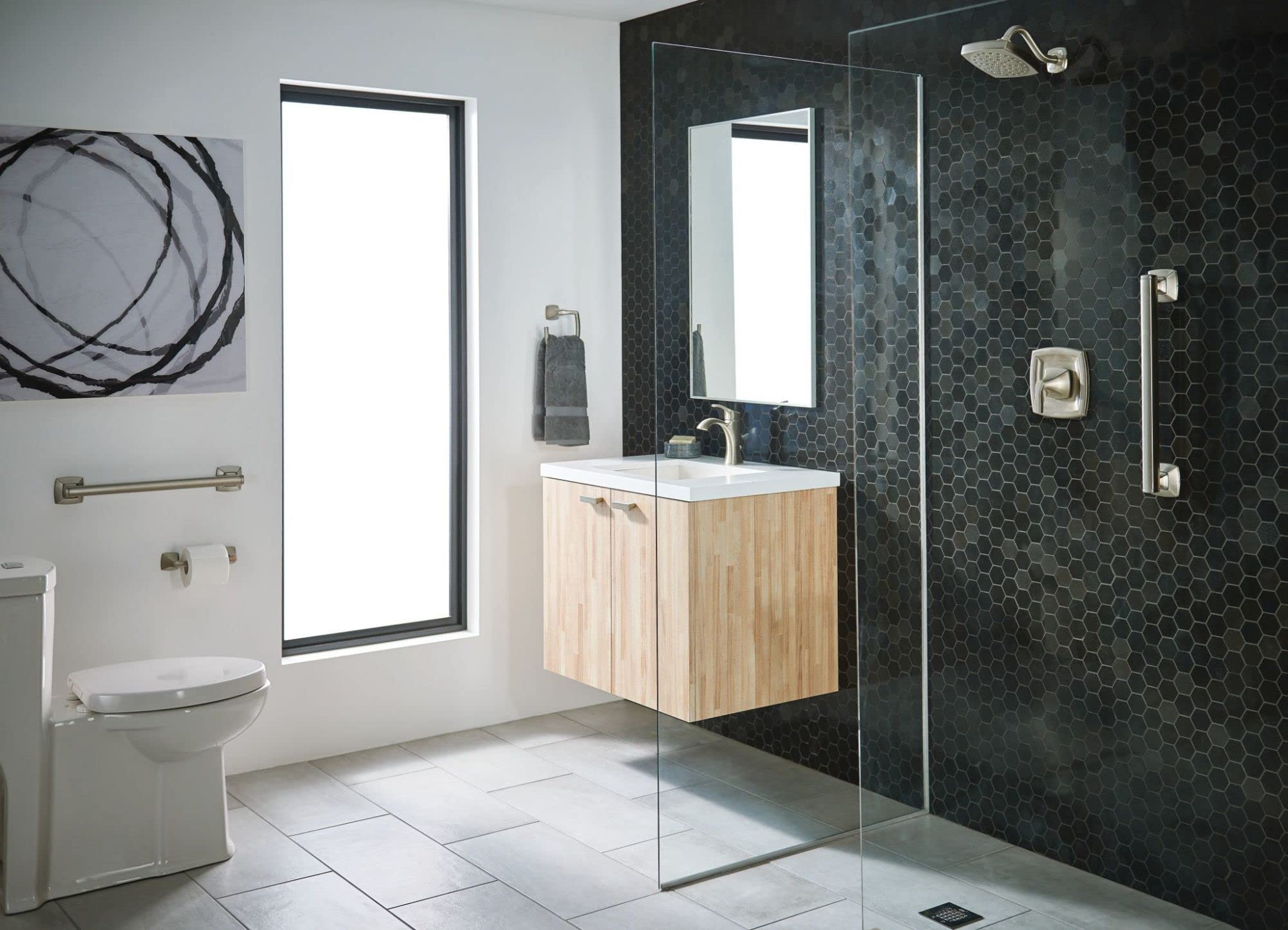 Brushed nickel pivoting toilet paper holder mounted on bathroom wall beside toilet.