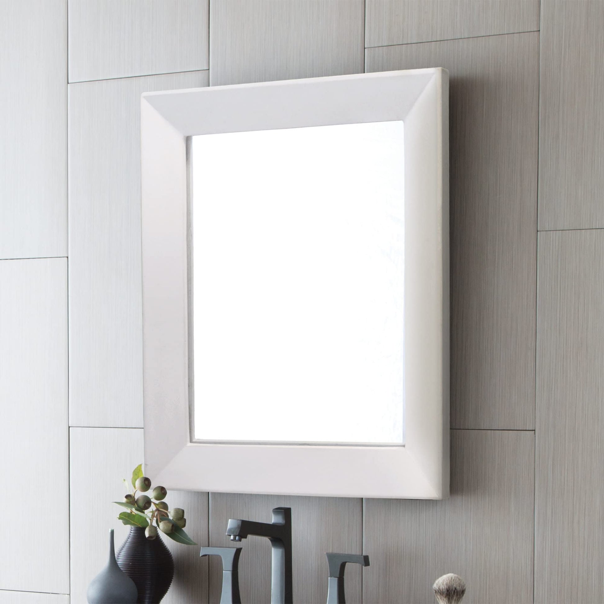 Pearl-finish framed mirror with white beveled edge mounted on tiled bathroom wall above decorative items.