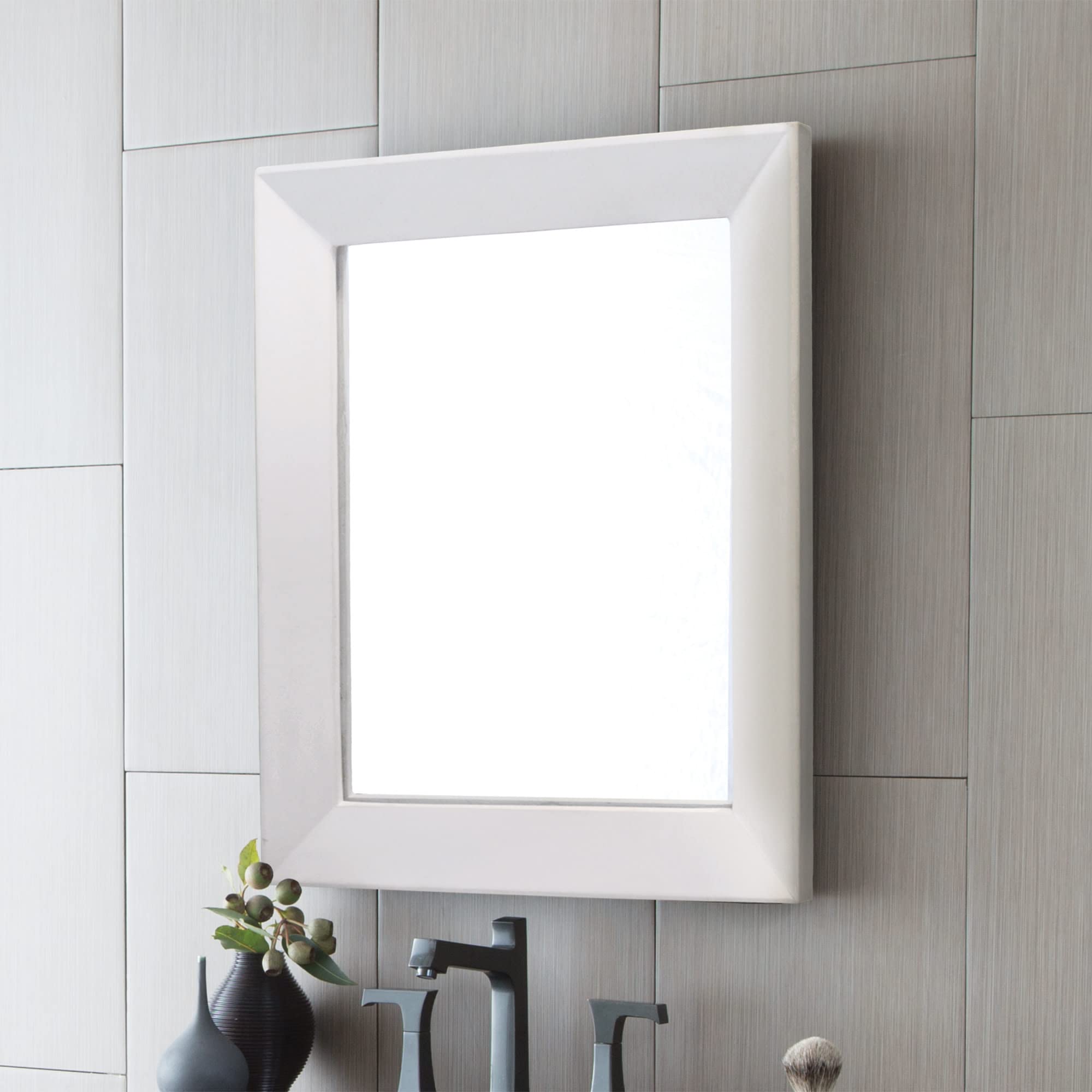 Pearl-finish framed mirror with white beveled edge mounted on tiled bathroom wall above decorative items.