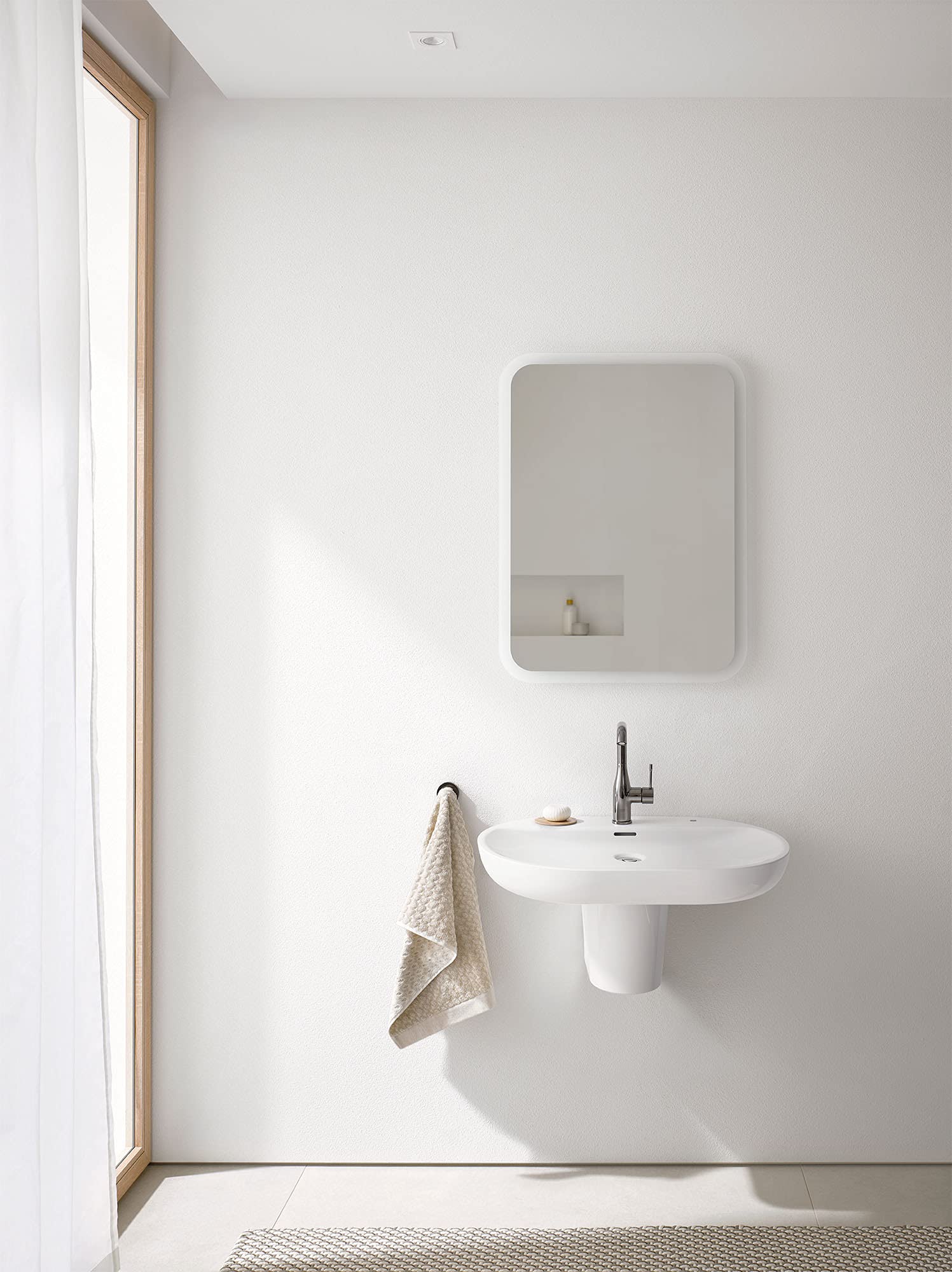 White rectangular wall-mounted shroud with rounded corners installed above bathroom sink.