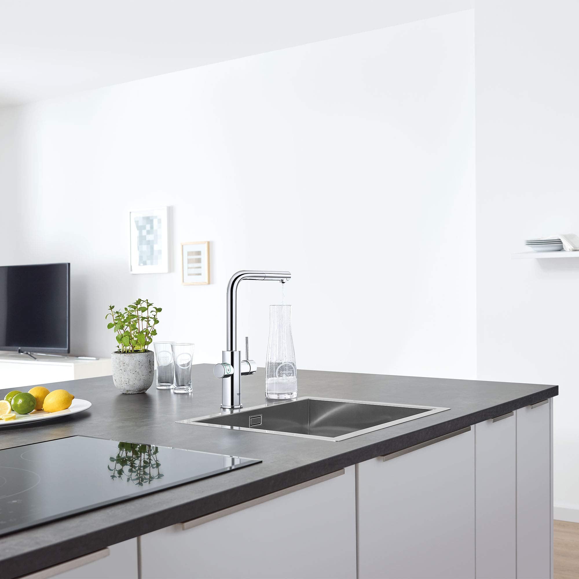 Chrome pull-out kitchen faucet with single handle mounted above stainless steel sink on dark countertop.