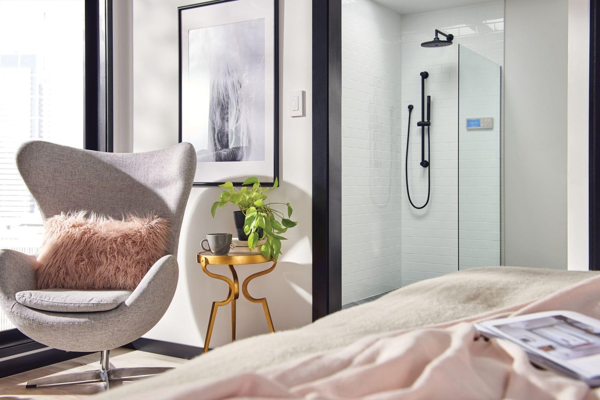 Wrought iron rainshower showerhead mounted on shower enclosure wall with water stream visible.