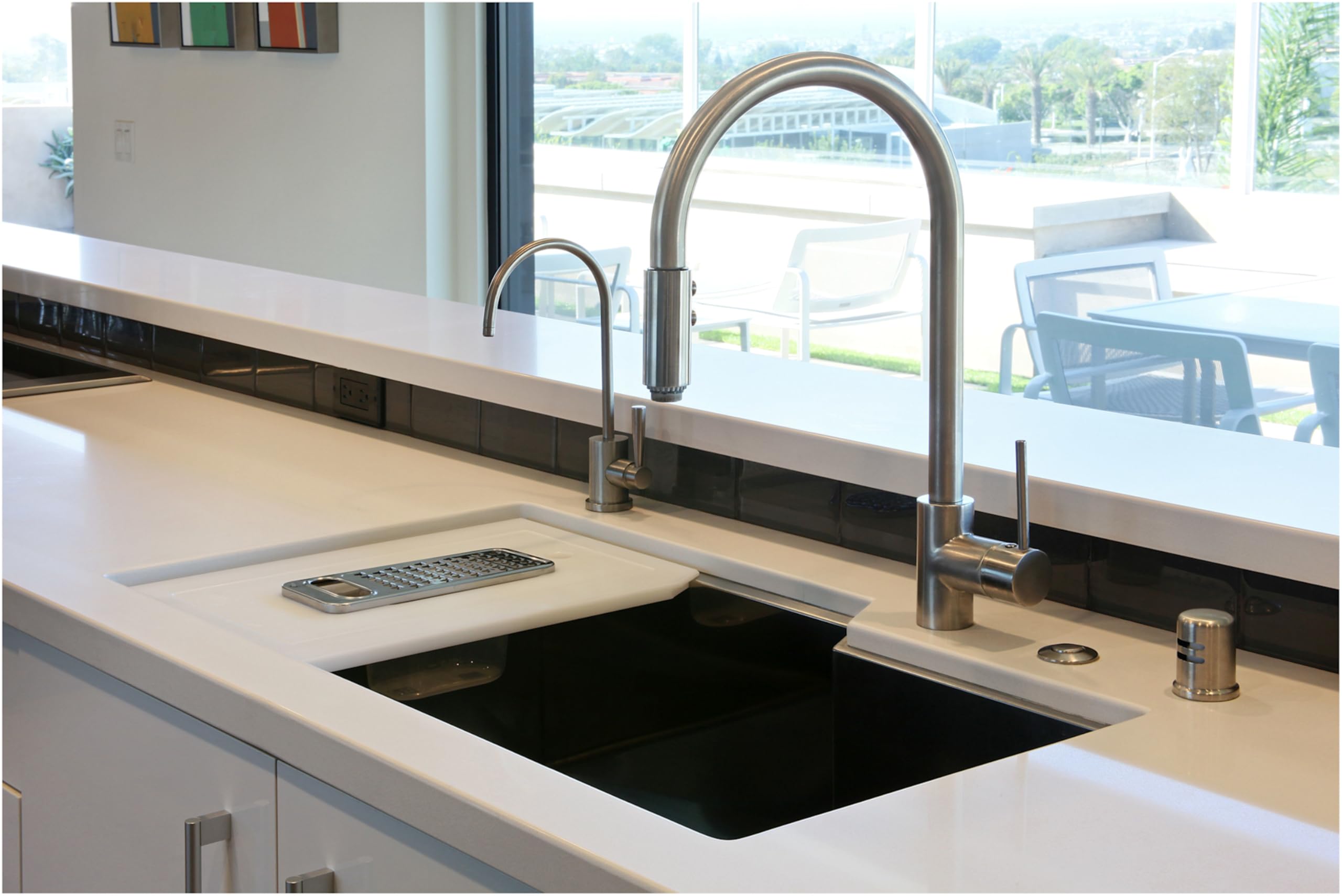 Satin English Gold air switch control box mounted on kitchen countertop next to sink with faucet.