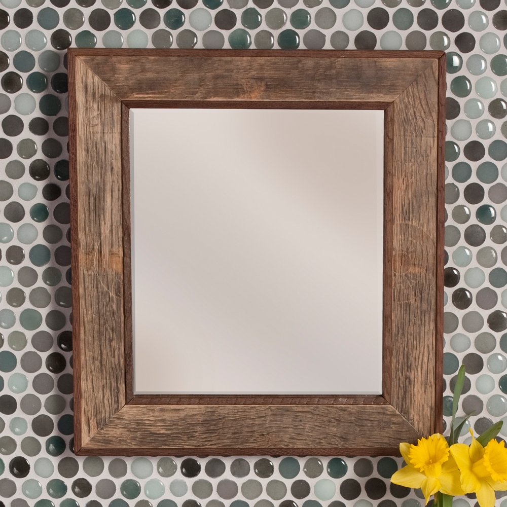 Rectangular mirror with rustic wood frame in warm brown finish, reflective surface, mounted on penny tile background.