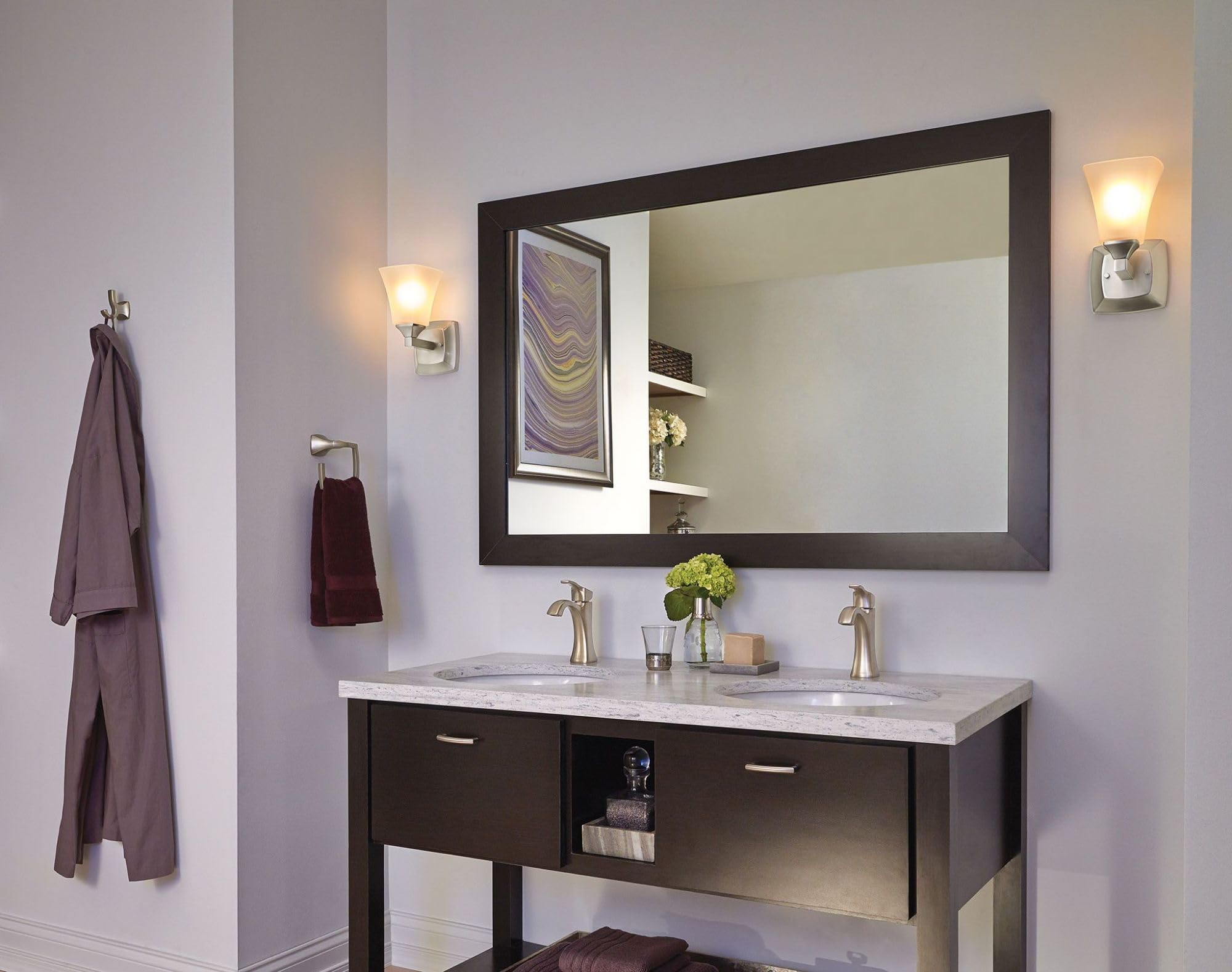 Brushed nickel double robe hook mounted on bathroom wall above sink vanity.