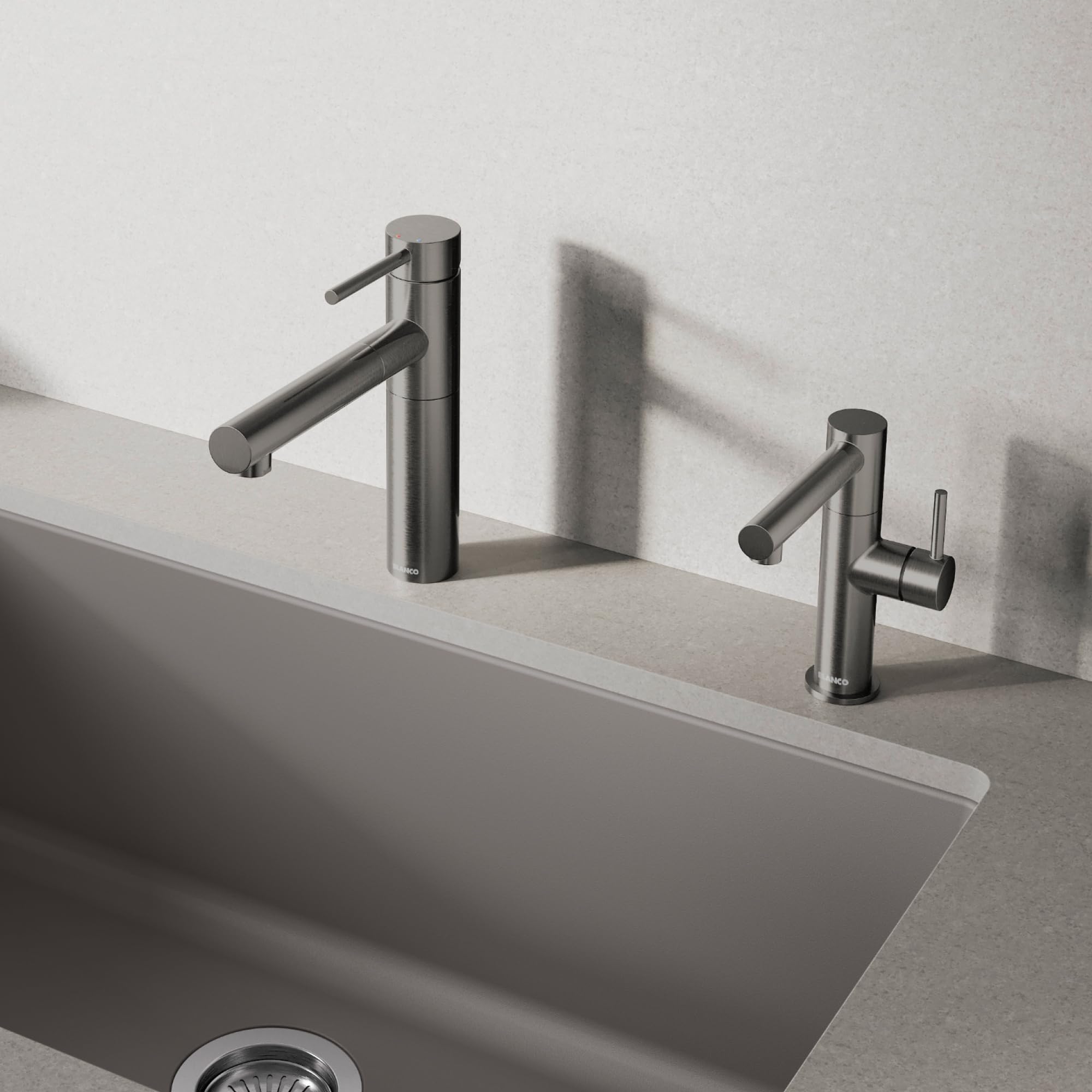 Satin dark steel pull-out kitchen faucet with tall cylindrical spout and lever handle mounted on sink deck.