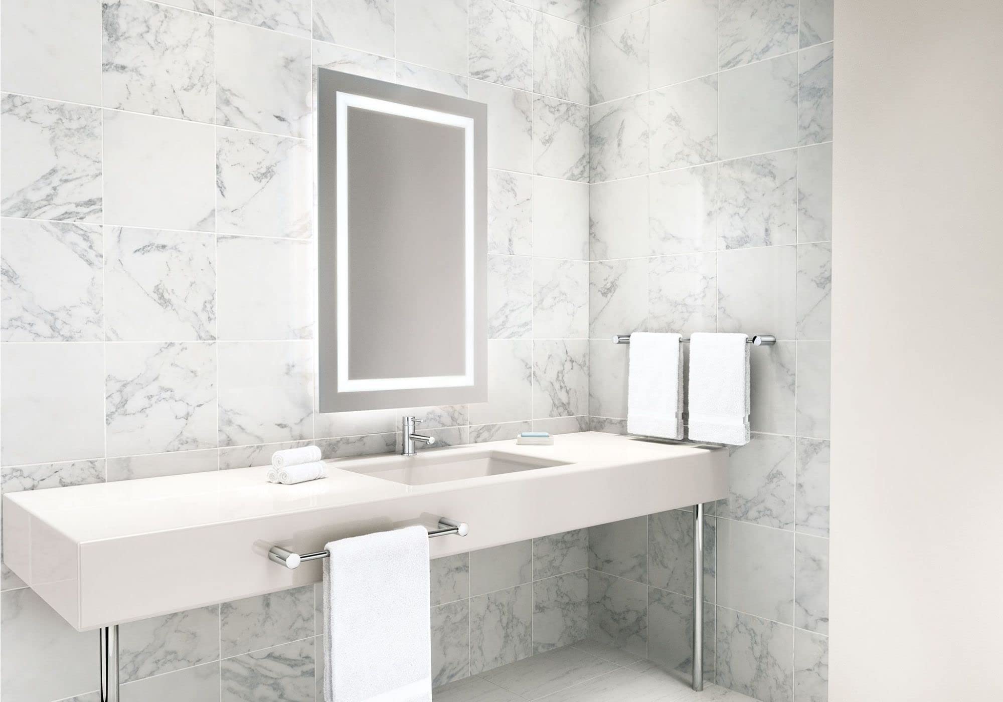 Chrome towel bar mounted on marble bathroom wall above white sink vanity with lit mirror.
