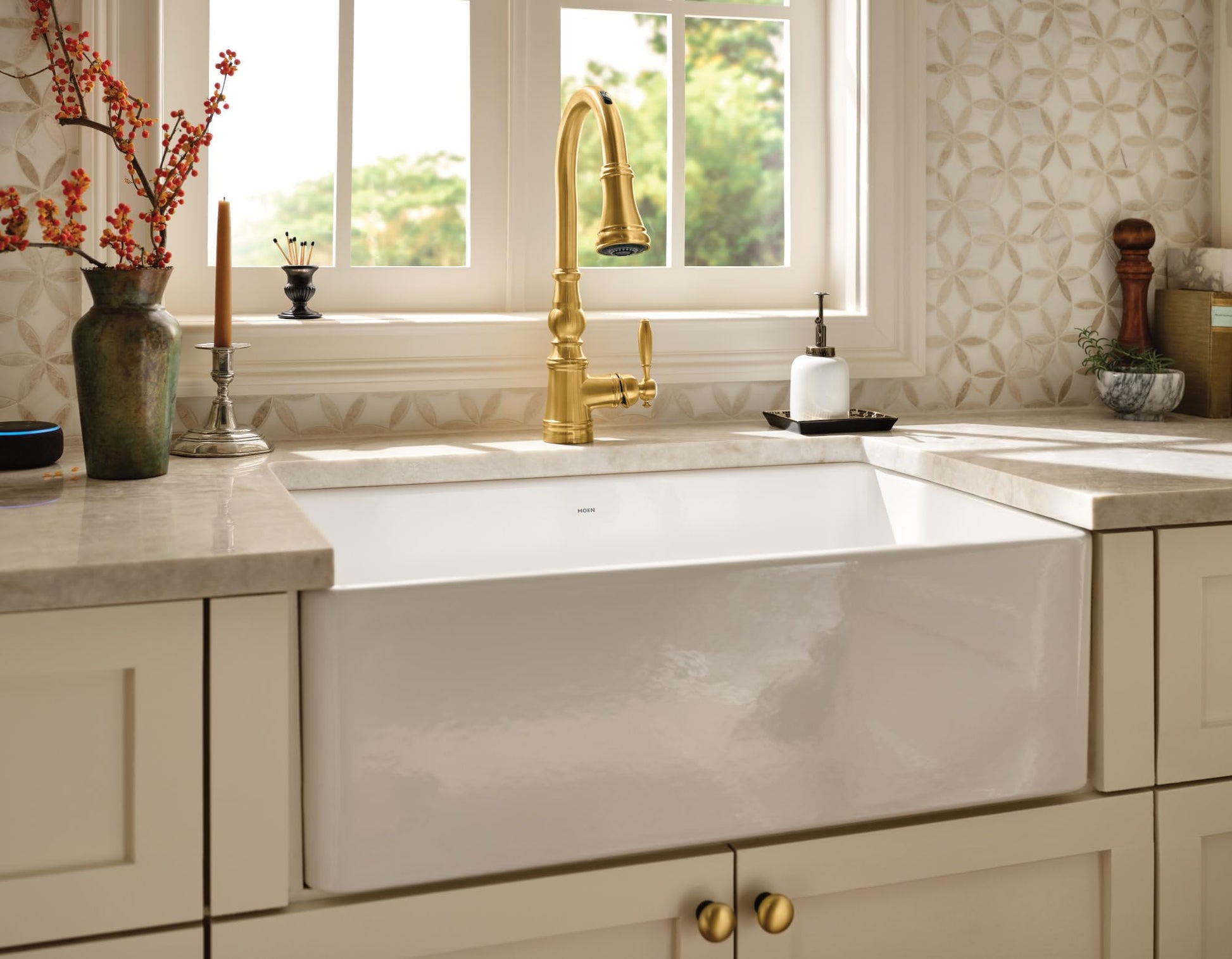 White fireclay apron front undermount kitchen sink with single bowl installed in cream cabinetry.