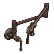 Oil rubbed bronze wall-mounted pot filler faucet with swing arm and two lever handles in traditional style.