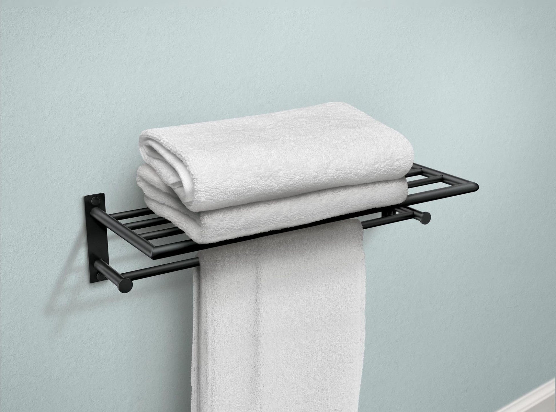 Matte black wall-mounted towel shelf with bar holding folded white towels against light blue wall.