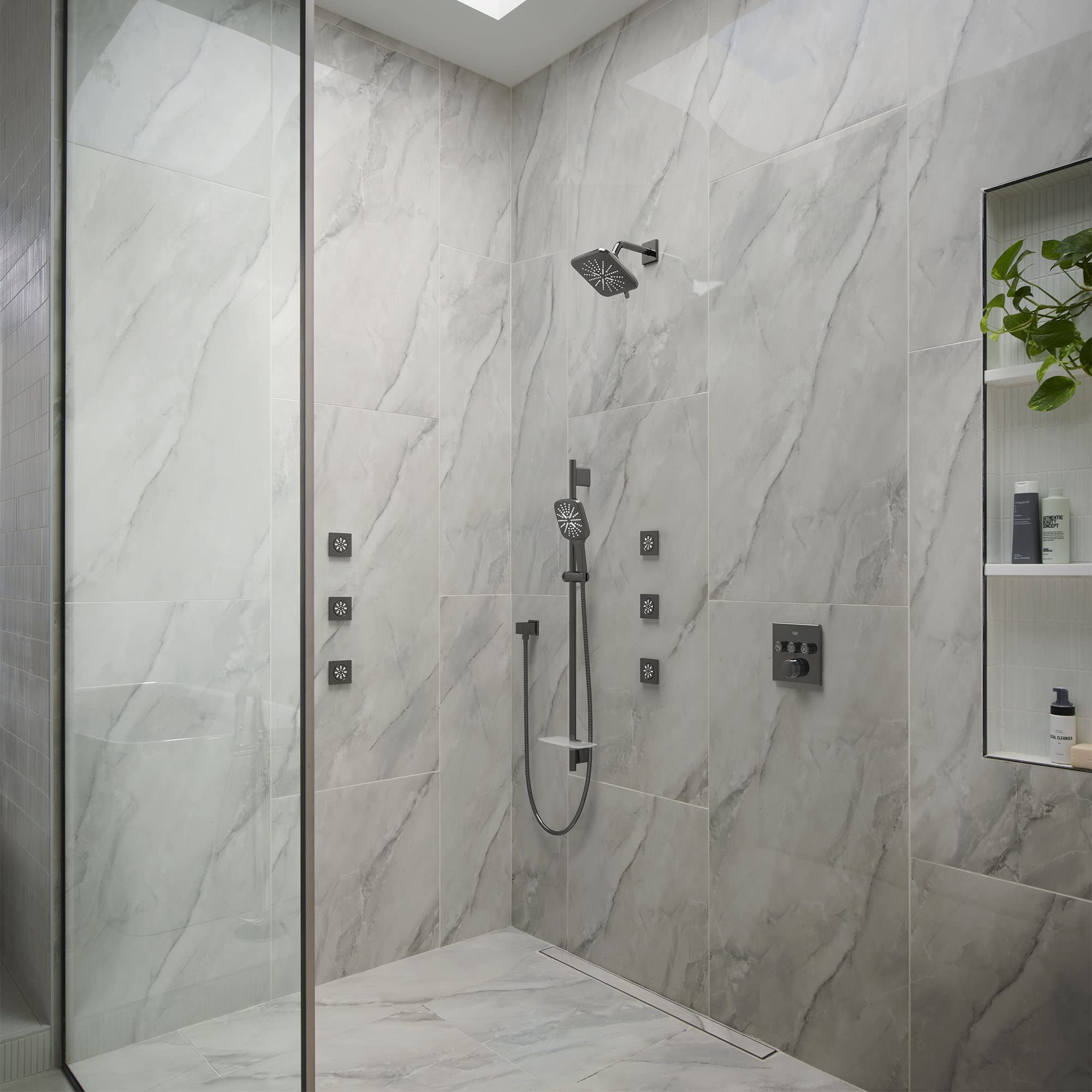 Dark graphite wall-mounted shower union with overhead and handheld showerheads in modern bathroom setting.