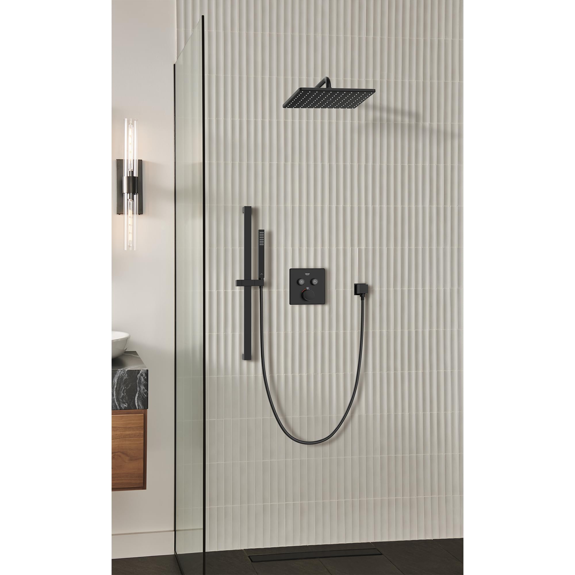 Matte black hand shower system with overhead shower head, wall-mounted control valve, and handheld shower on hose installed i