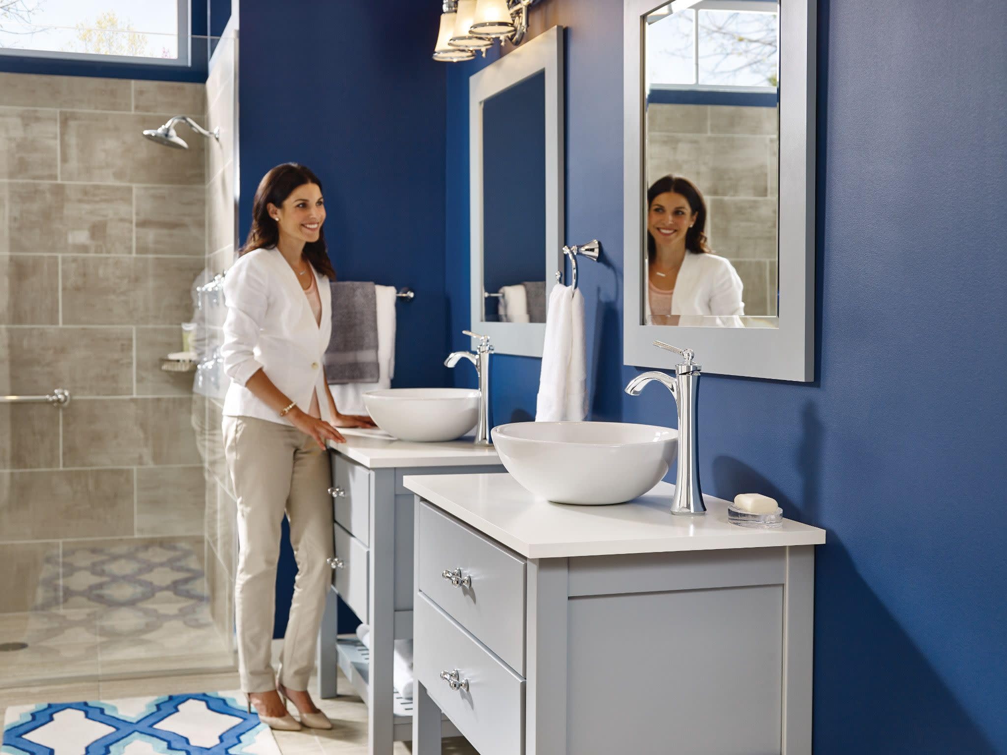 Chrome single-handle high arc faucet mounted on white vanity with round vessel sink in bathroom.
