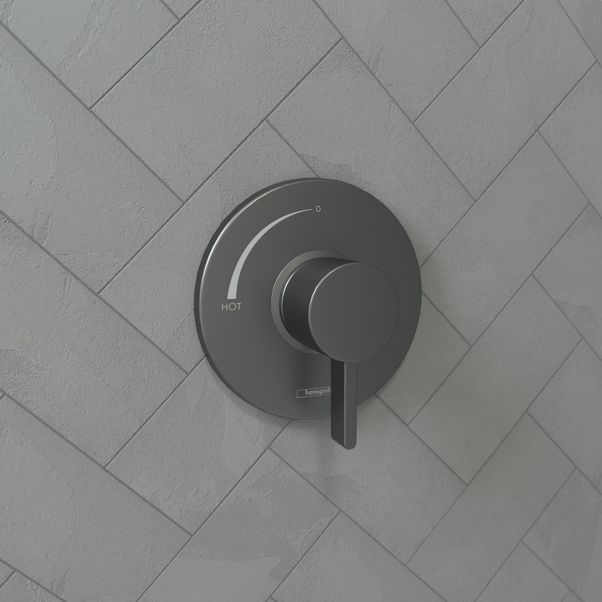 Brushed black chrome pressure balance trim with circular escutcheon plate and lever handle mounted on herringbone tile wall.