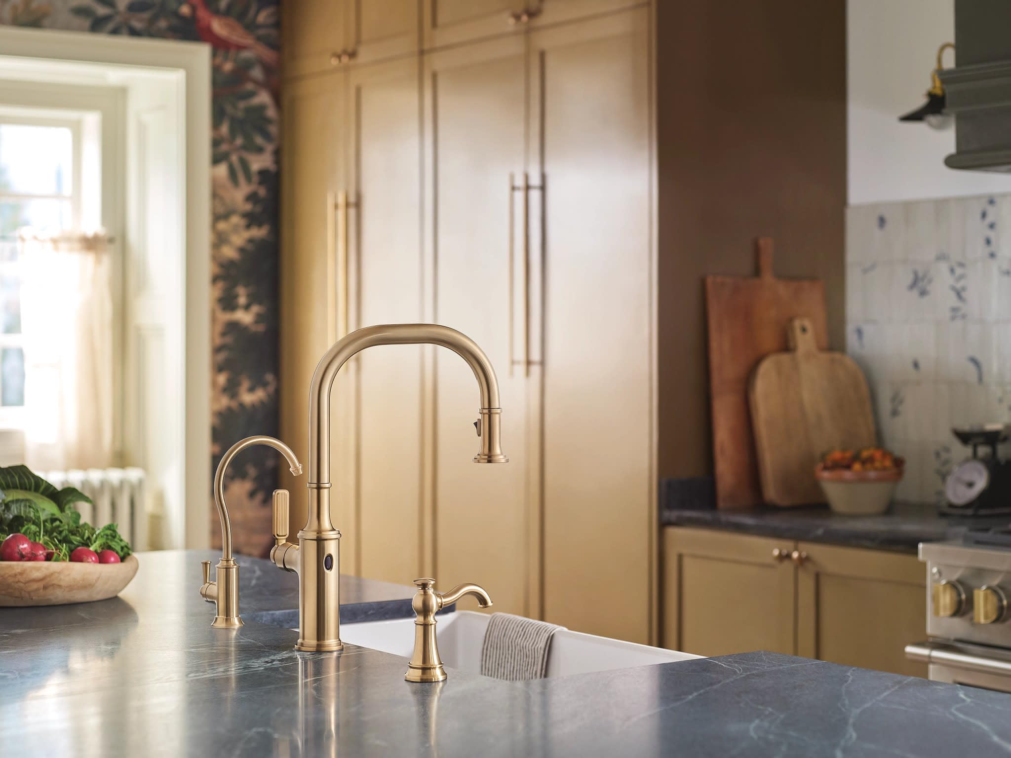 Brushed gold traditional kitchen faucet with curved spout and smaller accompanying beverage dispenser on countertop.
