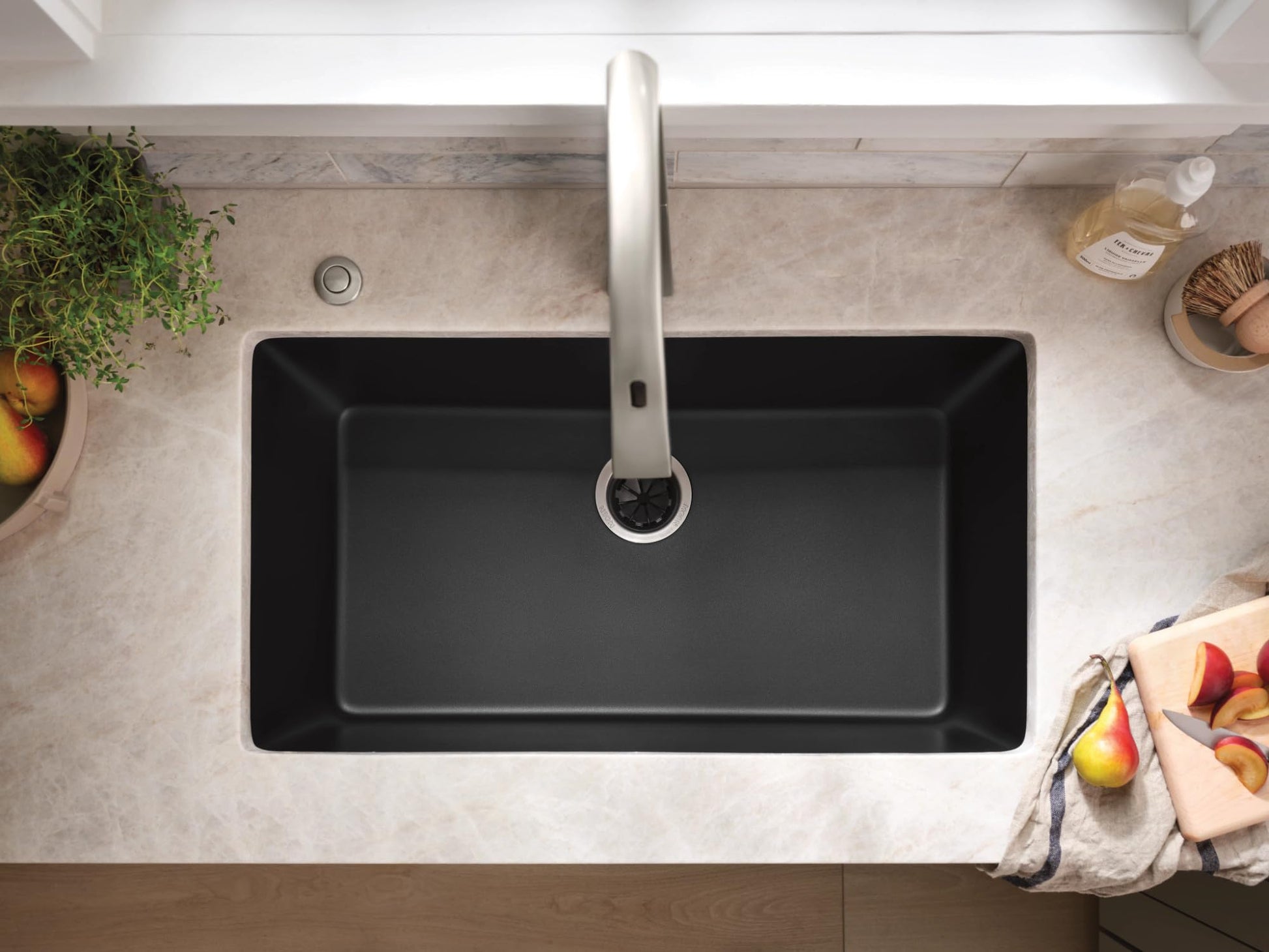 Matte black granite undermount kitchen sink with single rectangular bowl and chrome faucet, viewed from above.