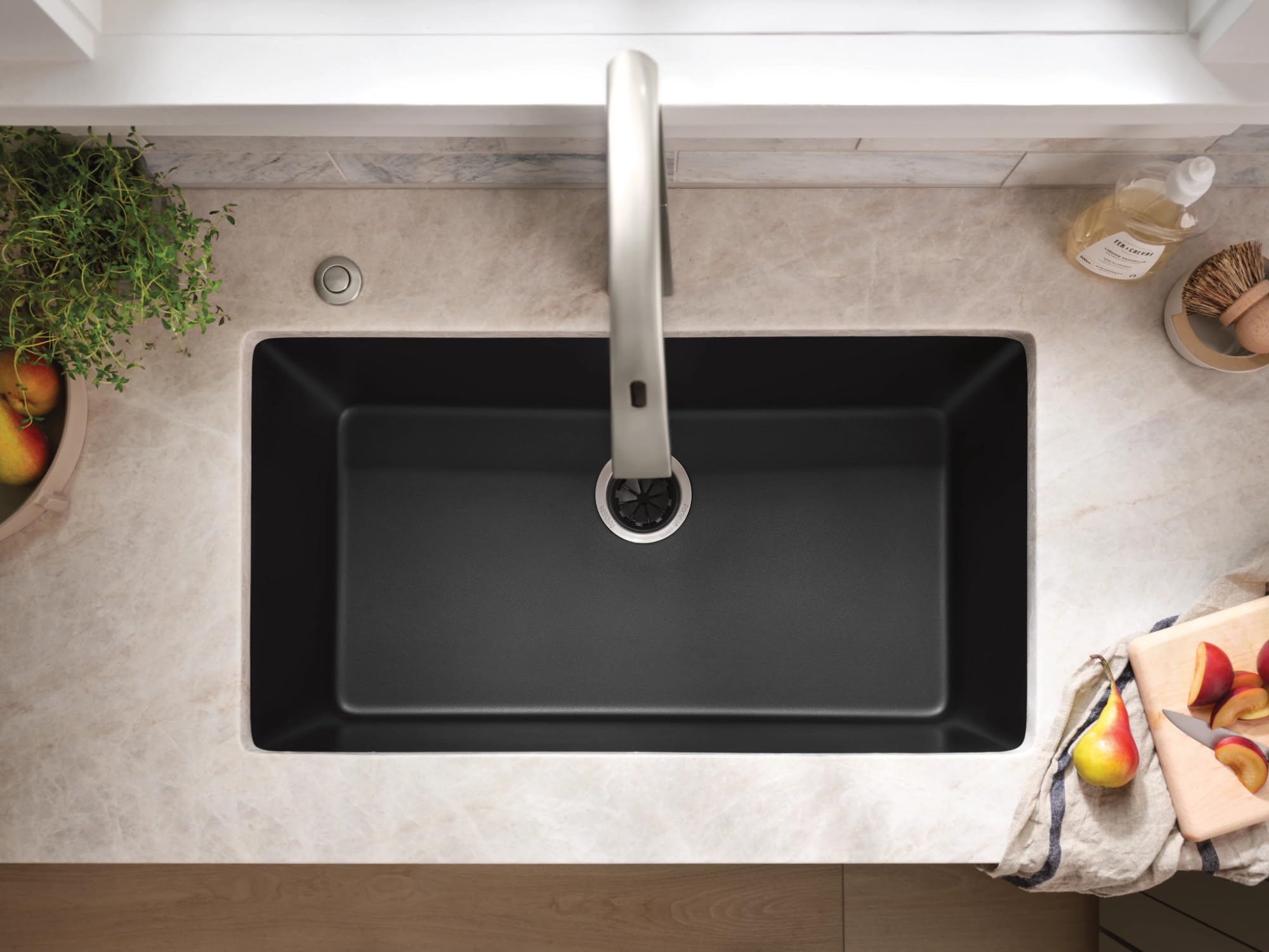 Matte black granite undermount kitchen sink with single rectangular bowl and chrome faucet, viewed from above.