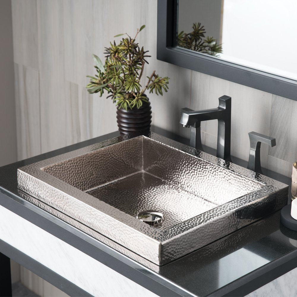 Polished nickel rectangular sink with hammered texture and two-compartment basin on bathroom countertop.