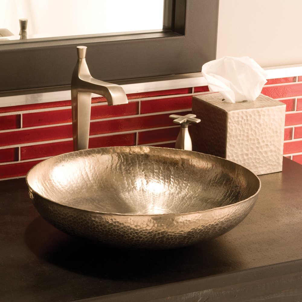 Hammered copper vessel sink with bowl shape and textured surface on bathroom counter.