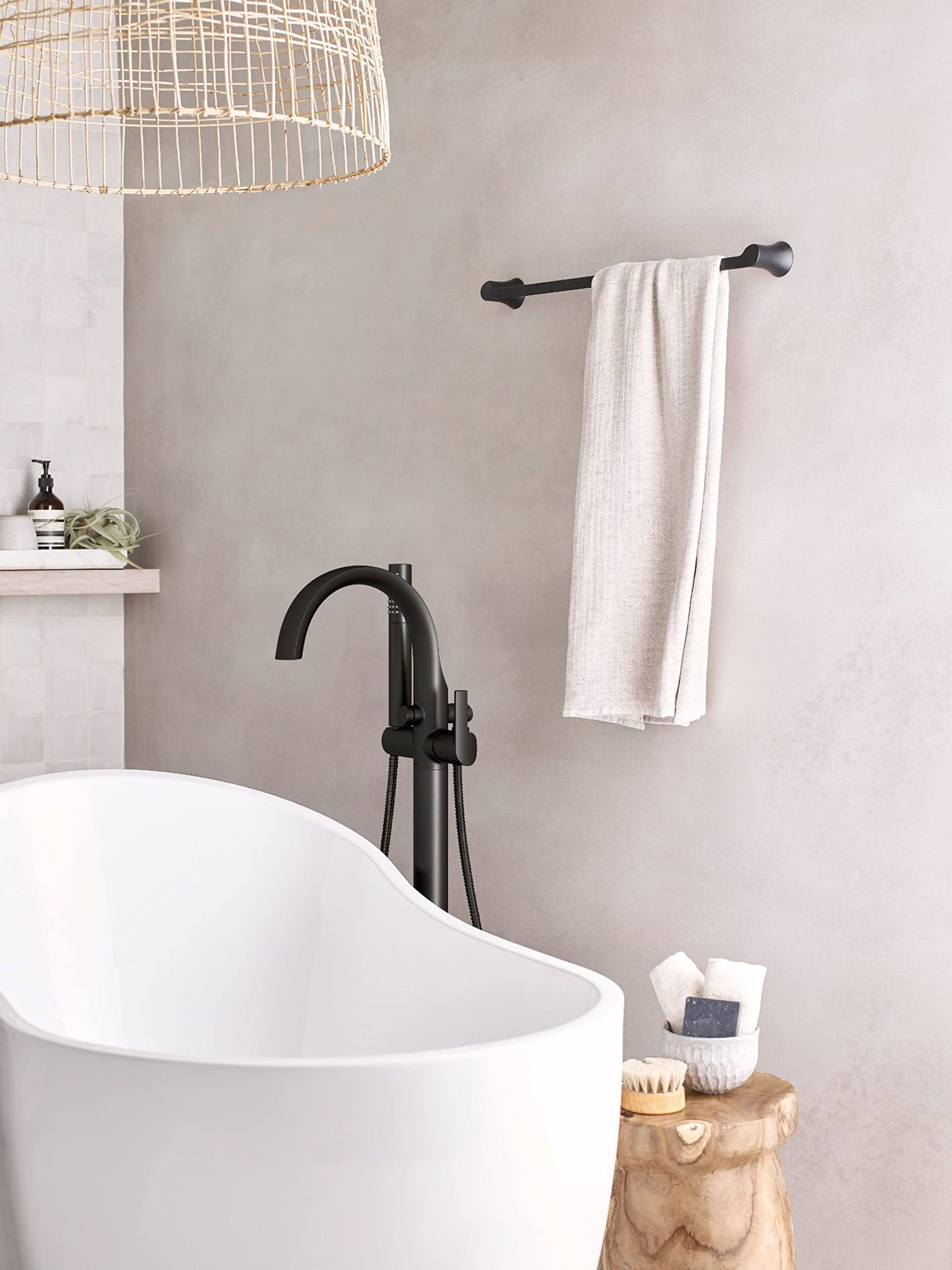 Matte black freestanding bathtub filler with curved spout, single handle, and detachable handshower on hose.