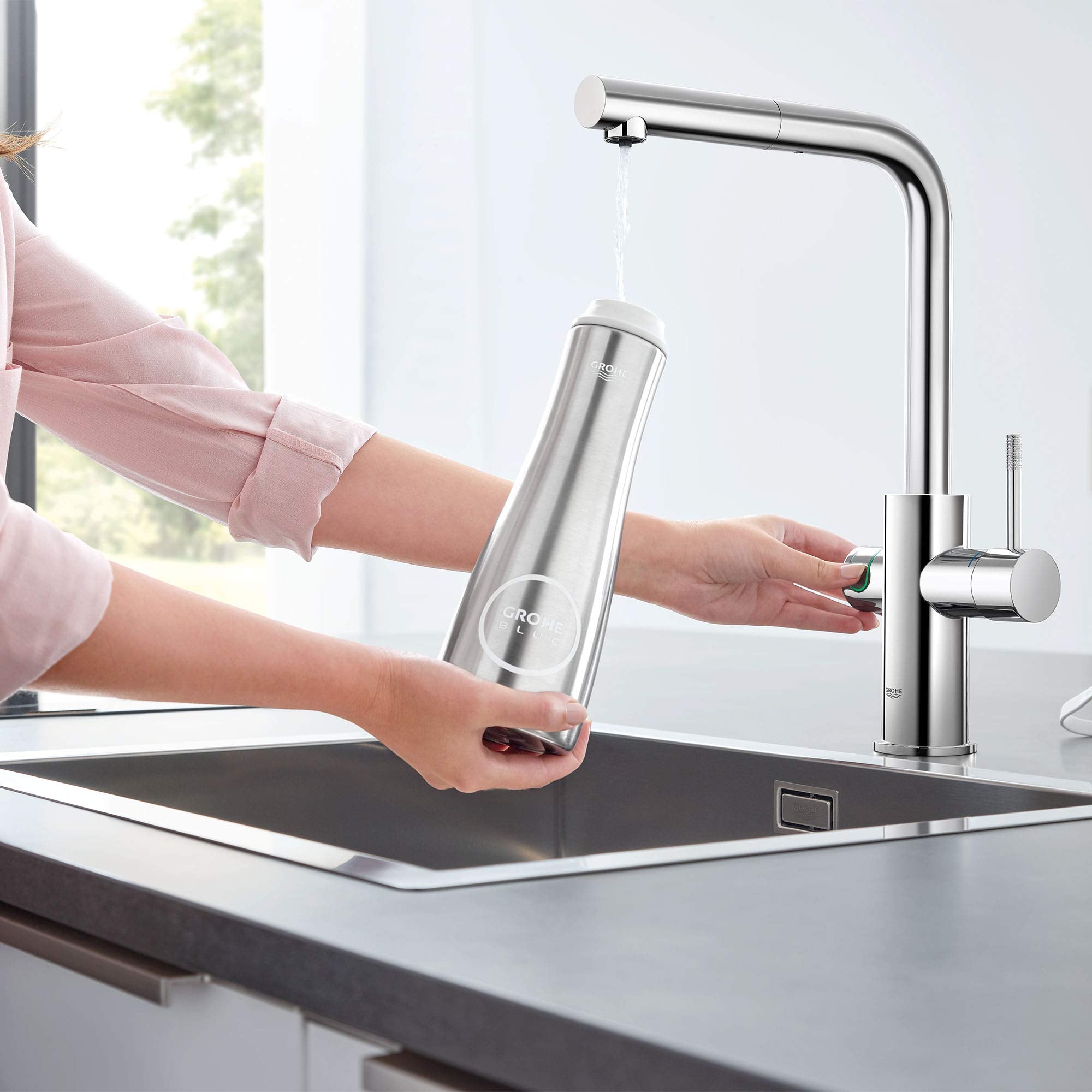Chrome pull-out kitchen faucet with single handle and integrated water filtration cartridge displayed over sink.