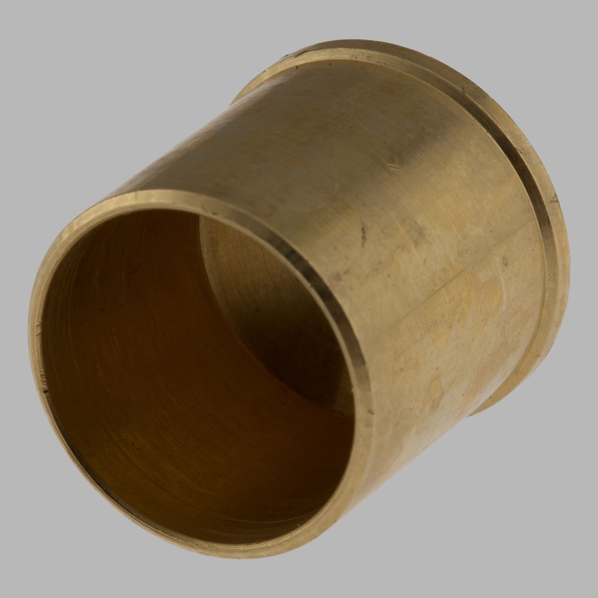 Brass cylindrical plug with grooved rim and angled end, shown at an angle revealing the hollow interior.