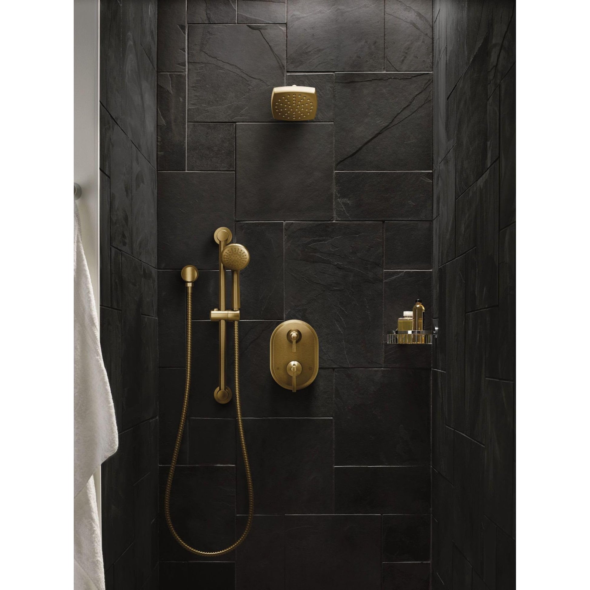 Polished nickel two-handle shower trim with overhead and handheld showerheads mounted on dark tile wall.