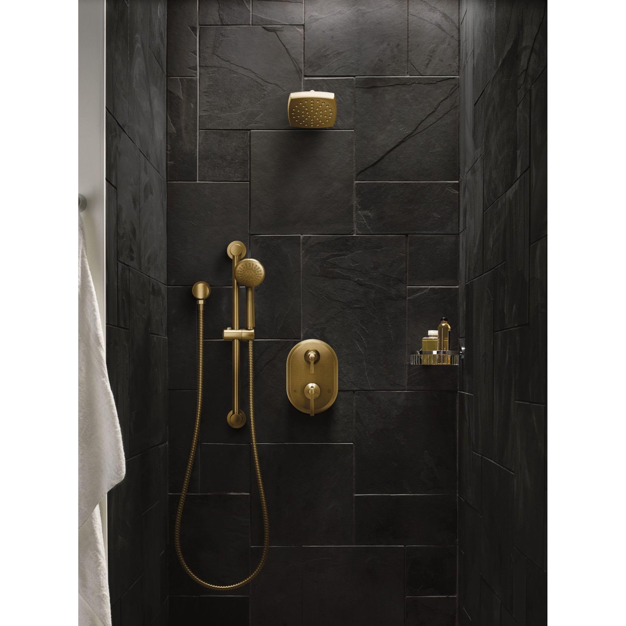 Polished nickel two-handle shower trim with overhead and handheld showerheads mounted on dark tile wall.
