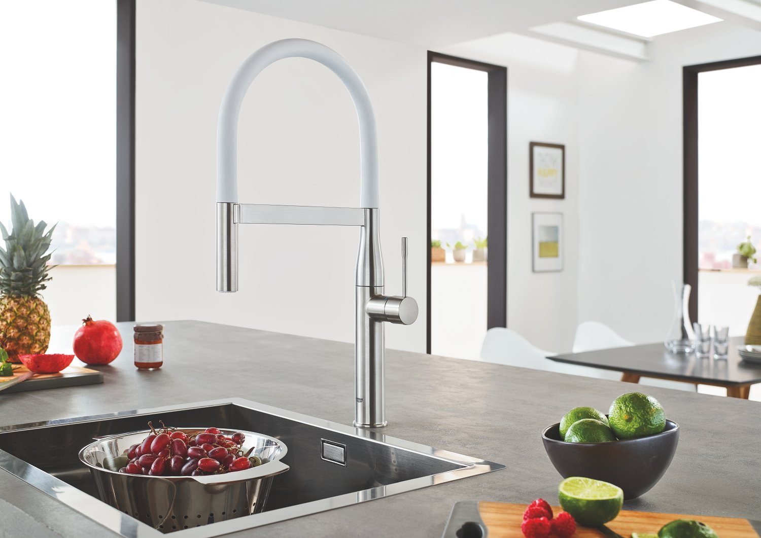 Polished chrome kitchen faucet with high arching spout and flexible hose attached to modern black sink countertop.