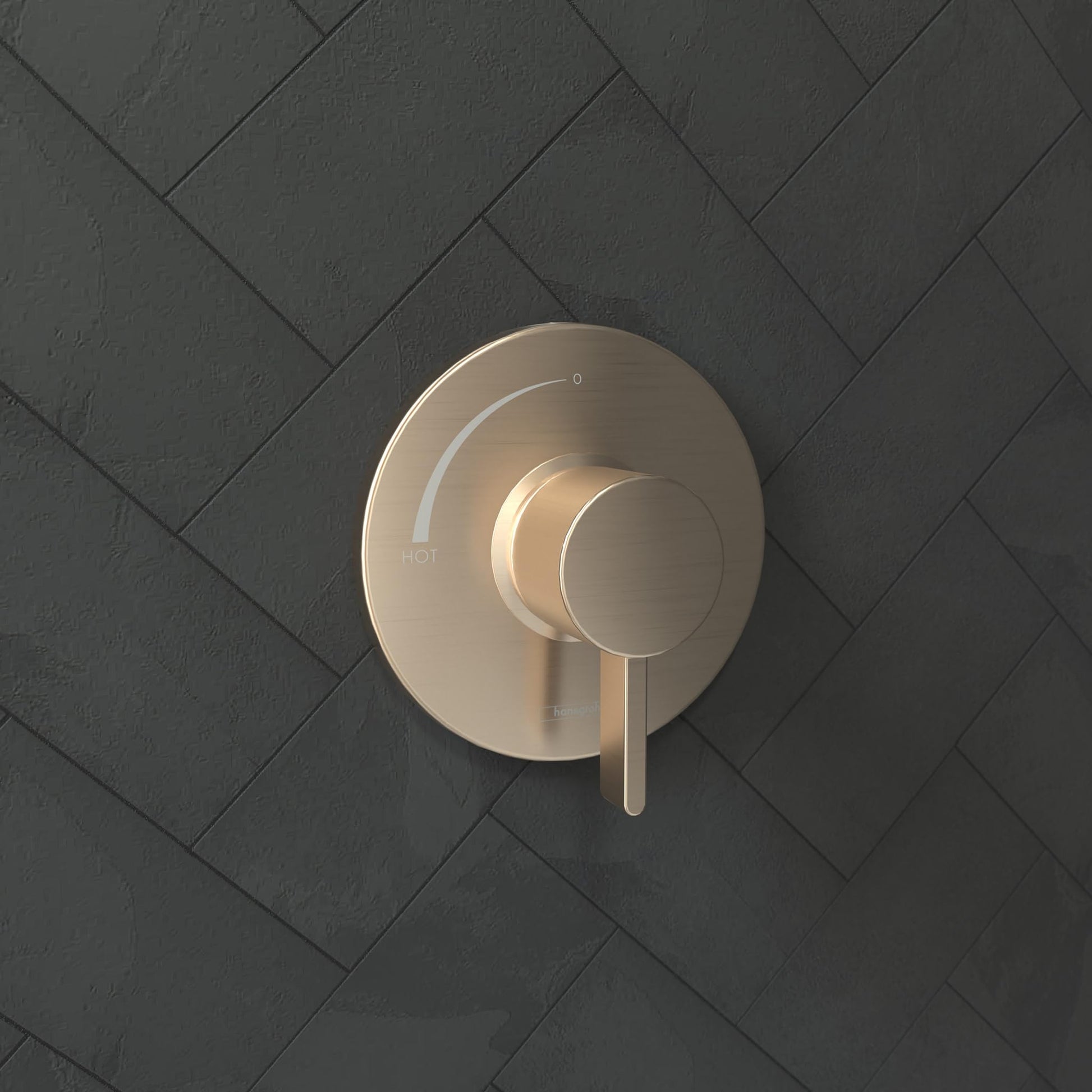 Brushed bronze round pressure balance valve trim with circular backplate and single lever handle mounted on herringbone tile 