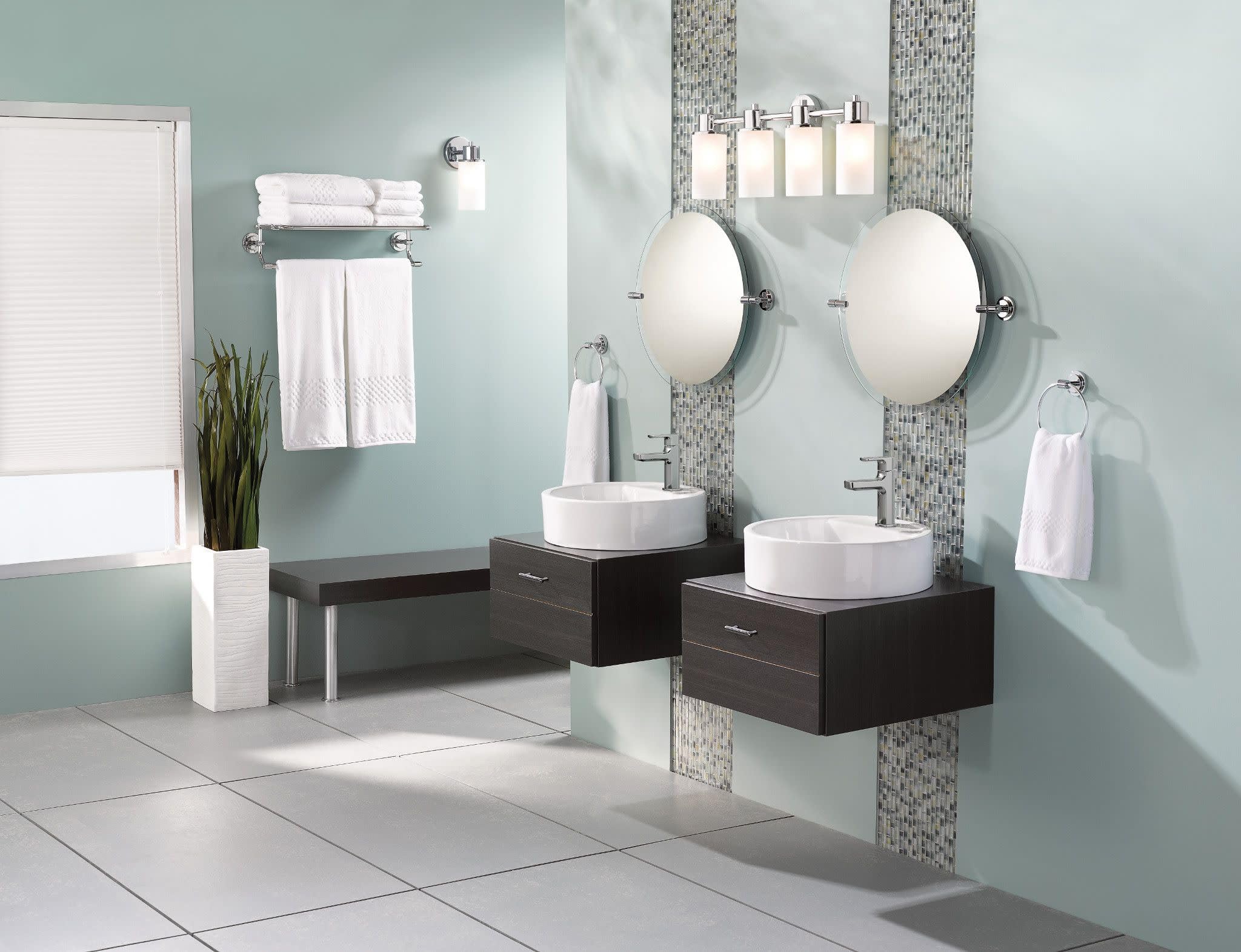 Chrome single-handle bathroom faucet mounted above white round sink on dark wood vanity.