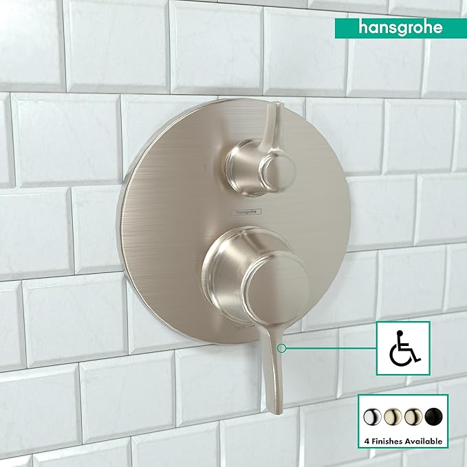 Round brushed nickel pressure balance valve trim with two knobs and diverter lever mounted on white subway tile.